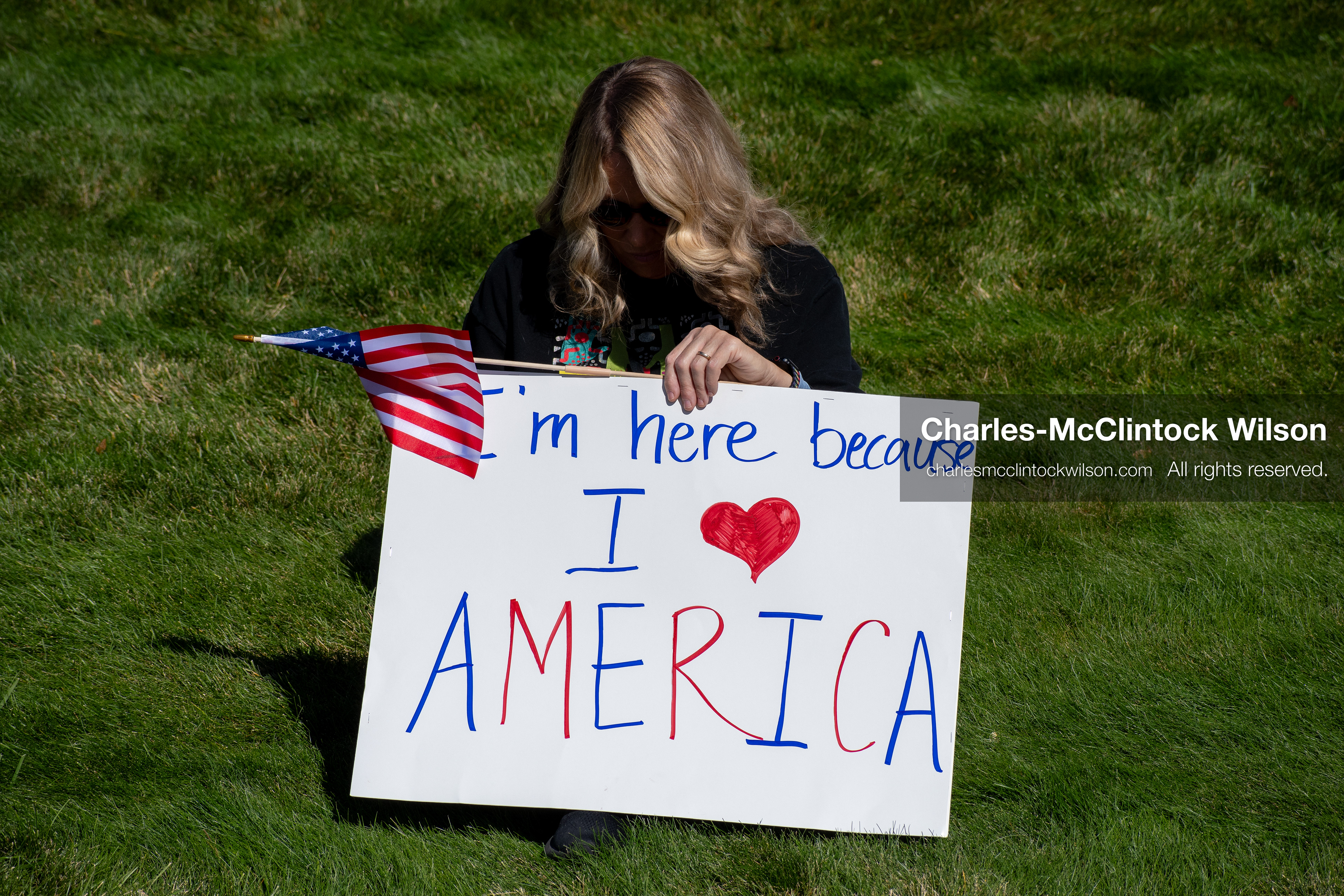 October 18, 2025, Salt Lake City, Utah, USA: A demonstrator raises a placard during a "No Kings" protest held at the Utah State Capitol. Other participants and signs are visible in the background during the public gathering.