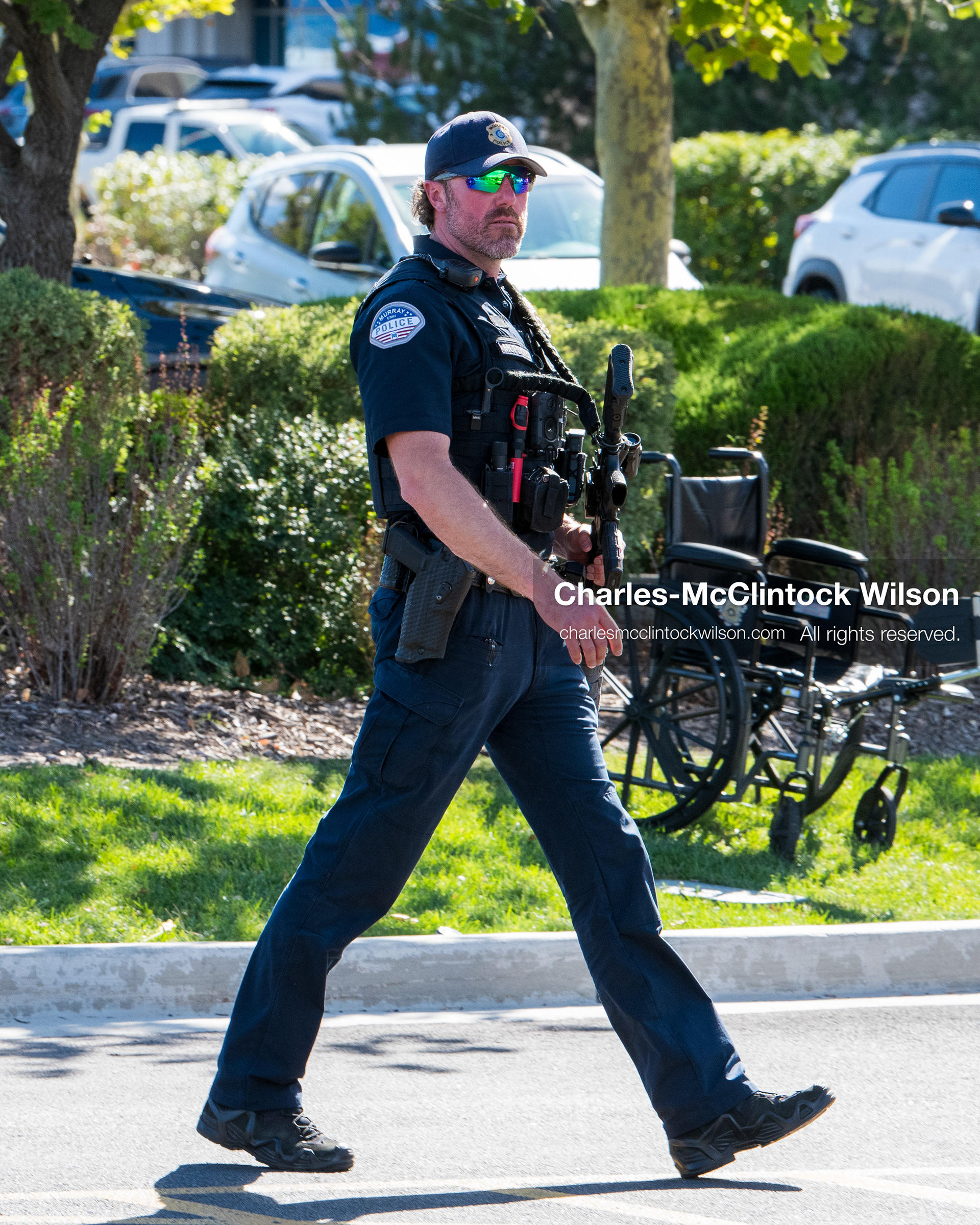 An armed law enforcement officer patrols a sidewalk perimeter outside Intermountain Medical Center in Murray, Utah, United States, on August 17, 2026. Multiple regional police agencies secured the hospital perimeter as a safety precaution after shooting victims were admitted following a fatal shootout outside a funeral service in nearby Kearns. (Photo by Charles-McClintock Wilson/NurPhoto)