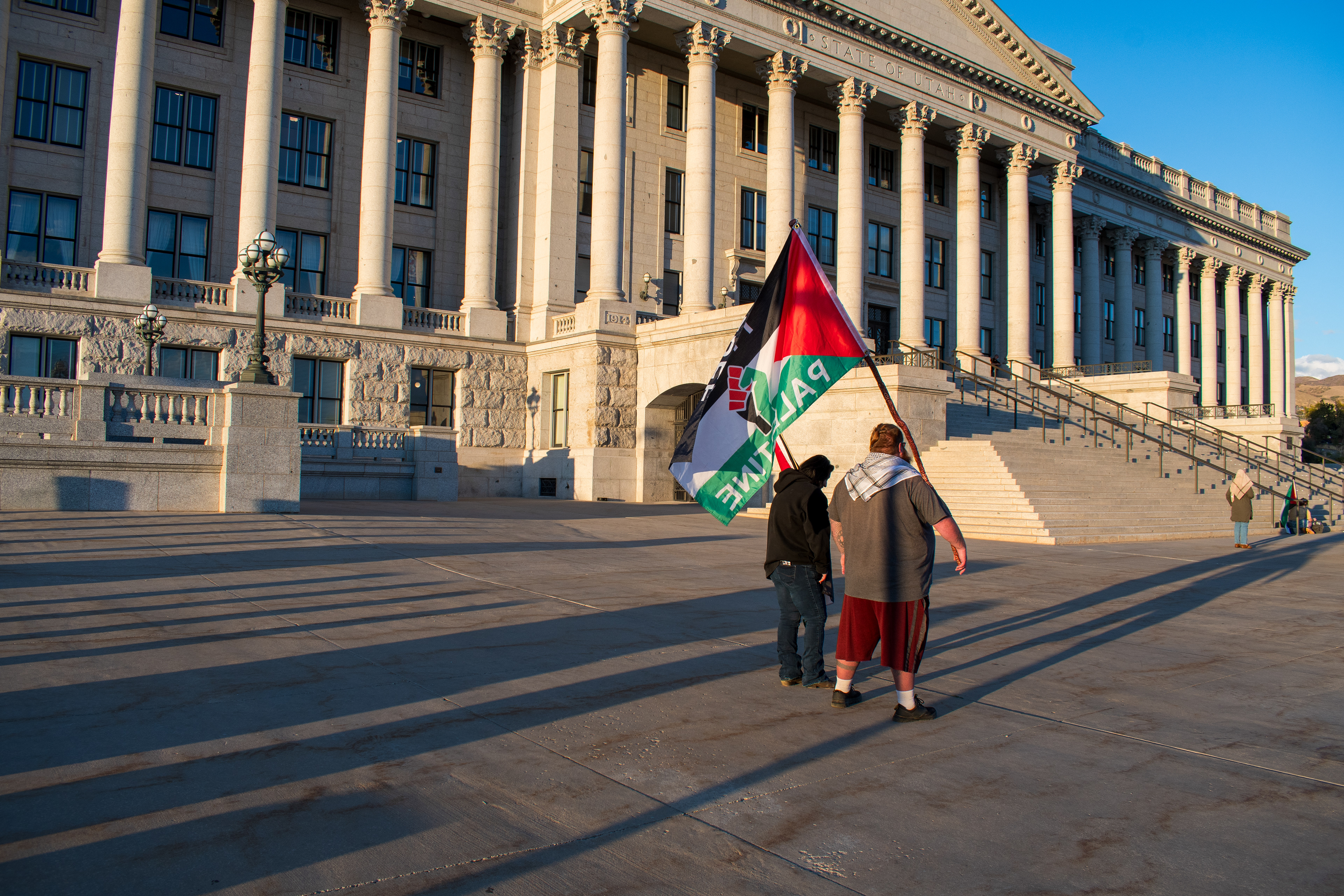 October 10, 2025, Salt Lake City, Utah, USA: Pro-Palestine demonstrators walk in front of the Utah State Capitol during the Free Palestine Rally. One participant carries a Palestinian flag near the building's neoclassical columns. (Credit Image: © Charles-McClintock Wilson/ZUMA Press Wire)