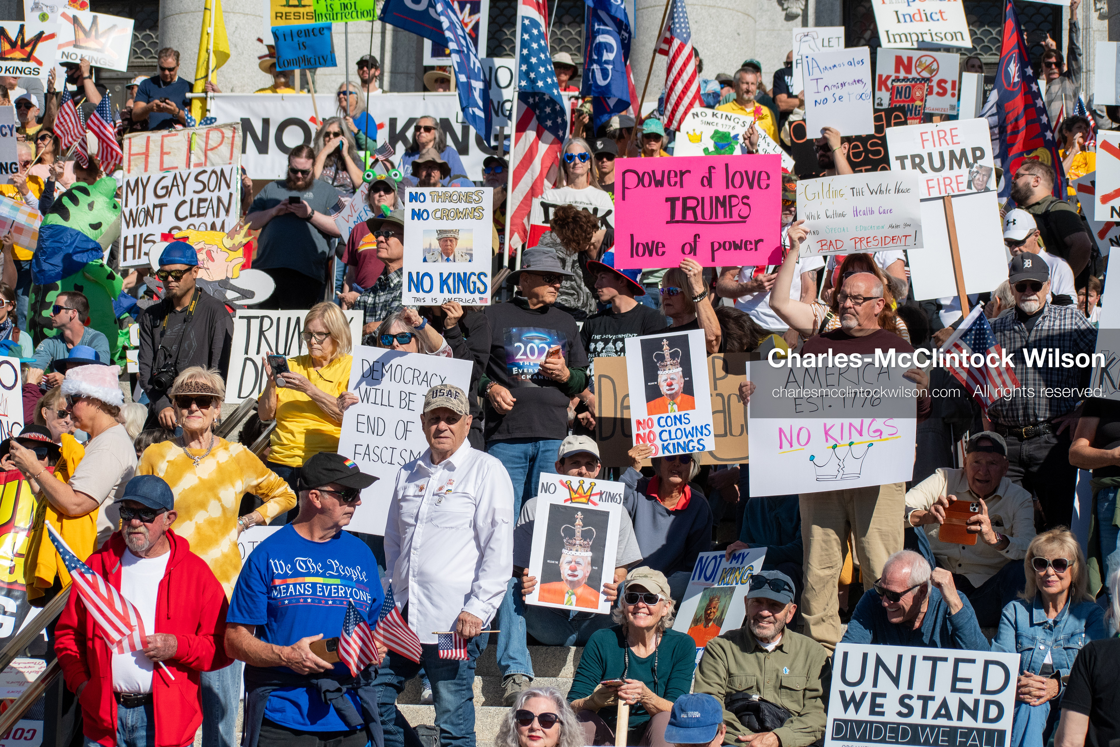 October 18, 2025, Salt Lake City, Utah, USA: Demonstrators gather on the steps of the Utah State Capitol during a "No Kings" protest held as part of a nationwide mobilization. Participants hold signs and flags while documenting the event. The protest was one of several organized across the United States.
