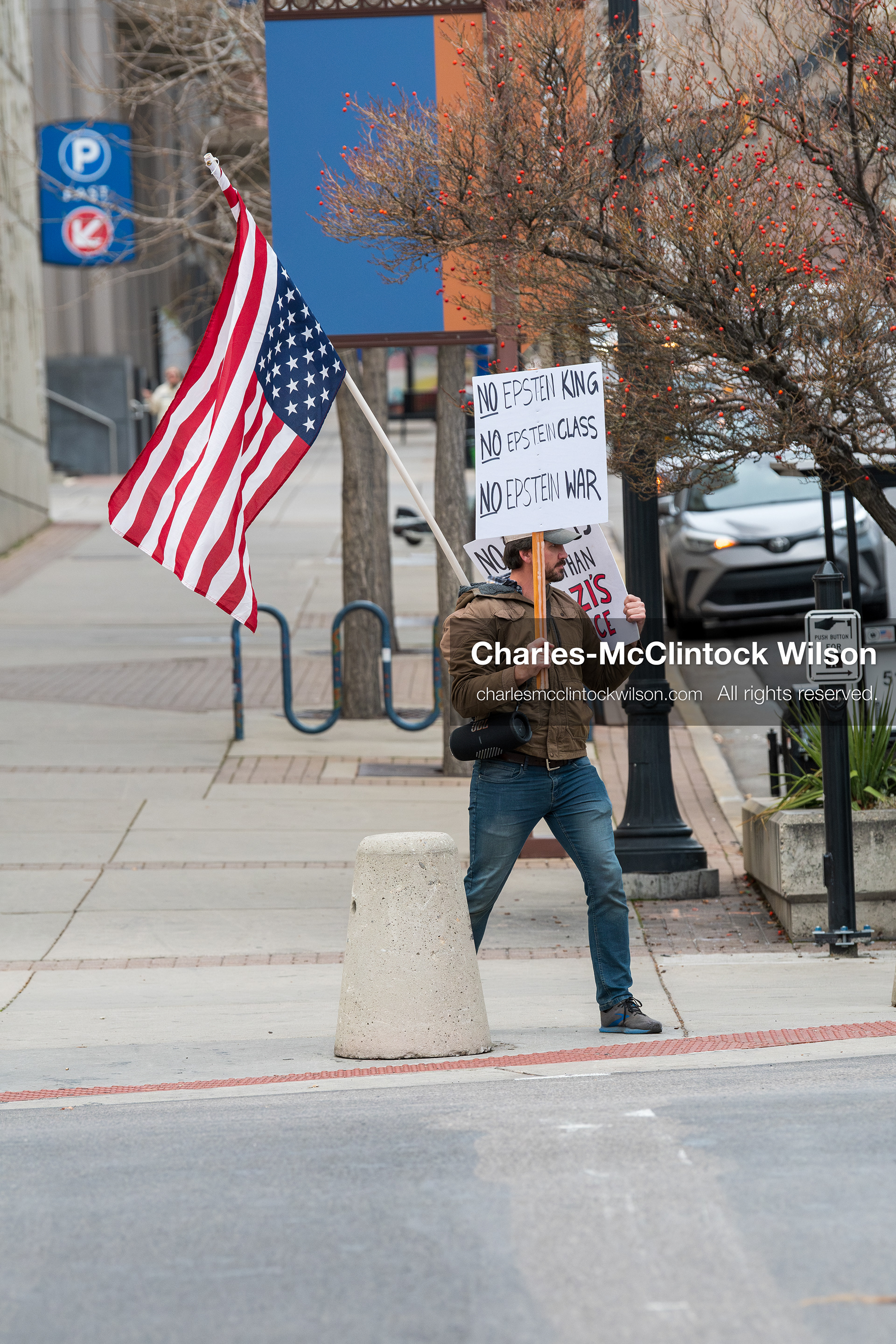 January 3, 2026, Salt Lake City, Utah, USA: A protester holds signs and an American flag during a demonstration against US action in Venezuela outside the Wallace Federal Building in Salt Lake City, Utah. The protest was part of a nationwide mobilization responding to recent military developments. (Credit Image: (c) Charles‑McClintock Wilson/ZUMA Press Wire)