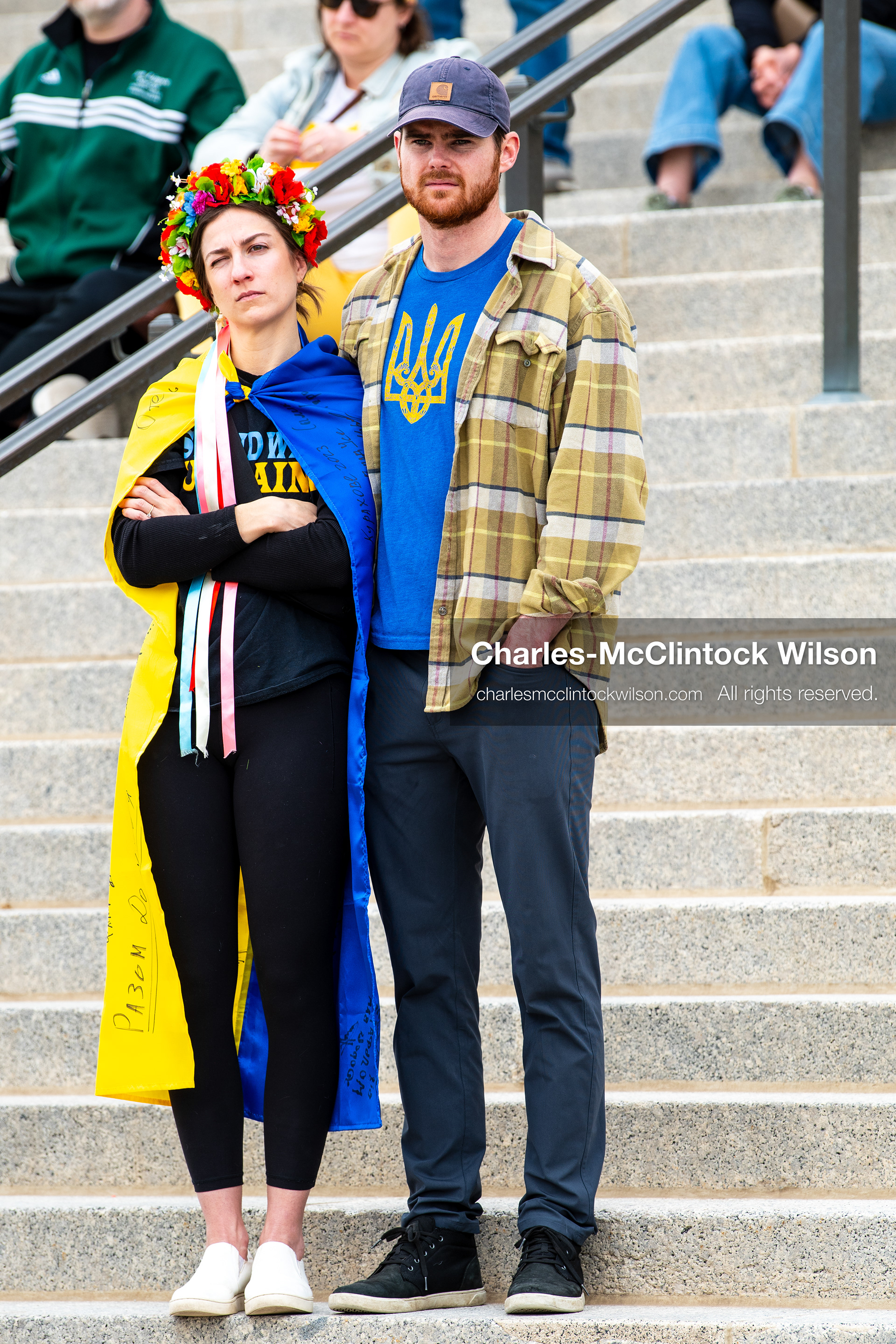 February 28, 2026, Salt Lake City, Utah, USA: Two demonstrators stand on the steps near the Utah State Capitol during the Stand With Ukraine rally, one wearing a blue and yellow cape with ribbons and a flower wreath, the other wearing a blue shirt with the Ukrainian trident. The gathering marked the four year anniversary of the full scale Russian invasion of Ukraine and brought community members together in support of Ukrainians and local humanitarian efforts. (Credit Image: © Charles McClintock Wilson/ZUMA Press Wire)