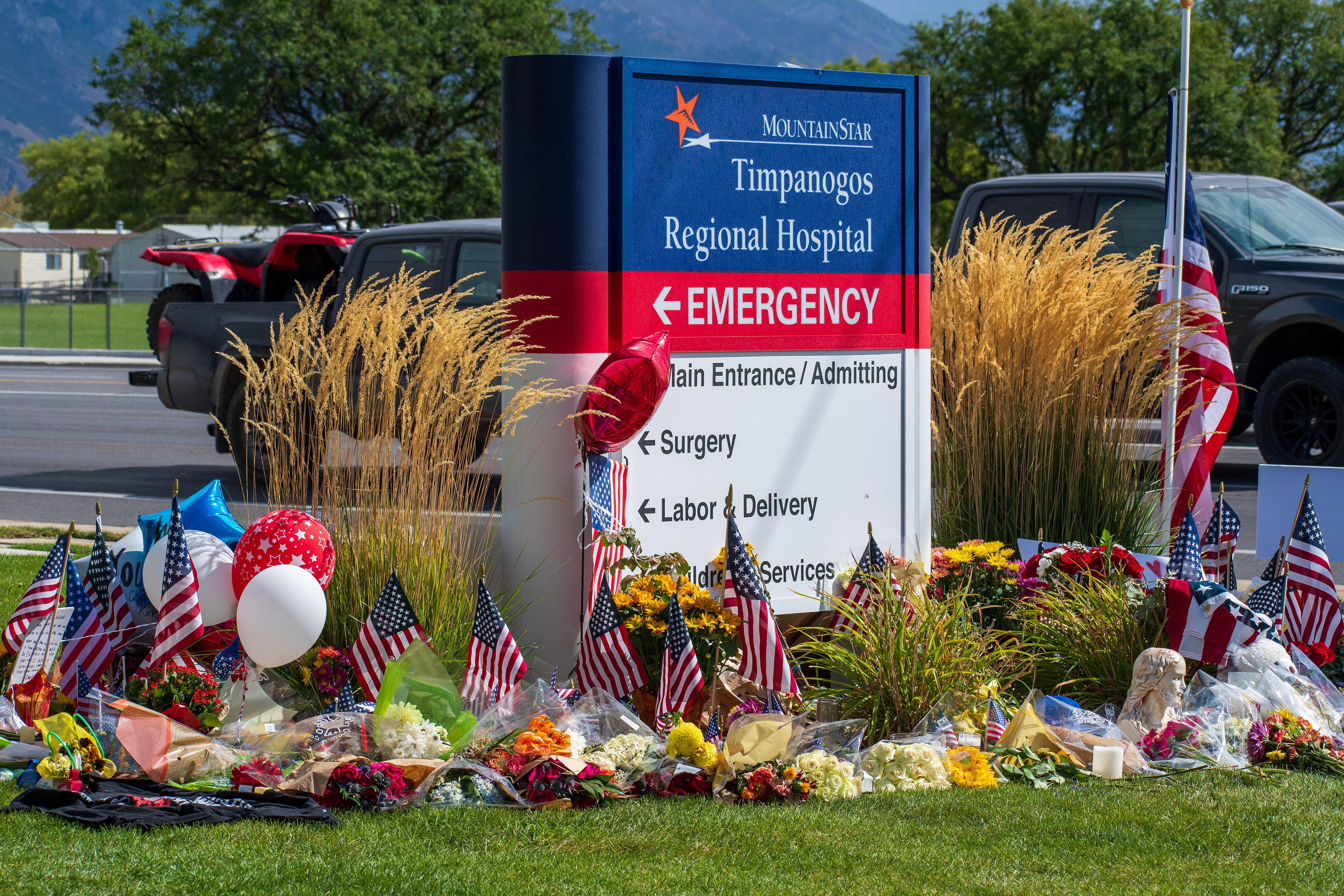 OREM, UTAH – SEPTEMBER 12, 2025: A memorial site for Charlie Kirk is seen in front of the MountainStar Timpanogos Regional Hospital sign near the Emergency Room entrance. American flags, balloons, flowers, and decorative items are arranged on the grass beside the roadside. © Charles‑McClintock Wilson / ZUMA Press