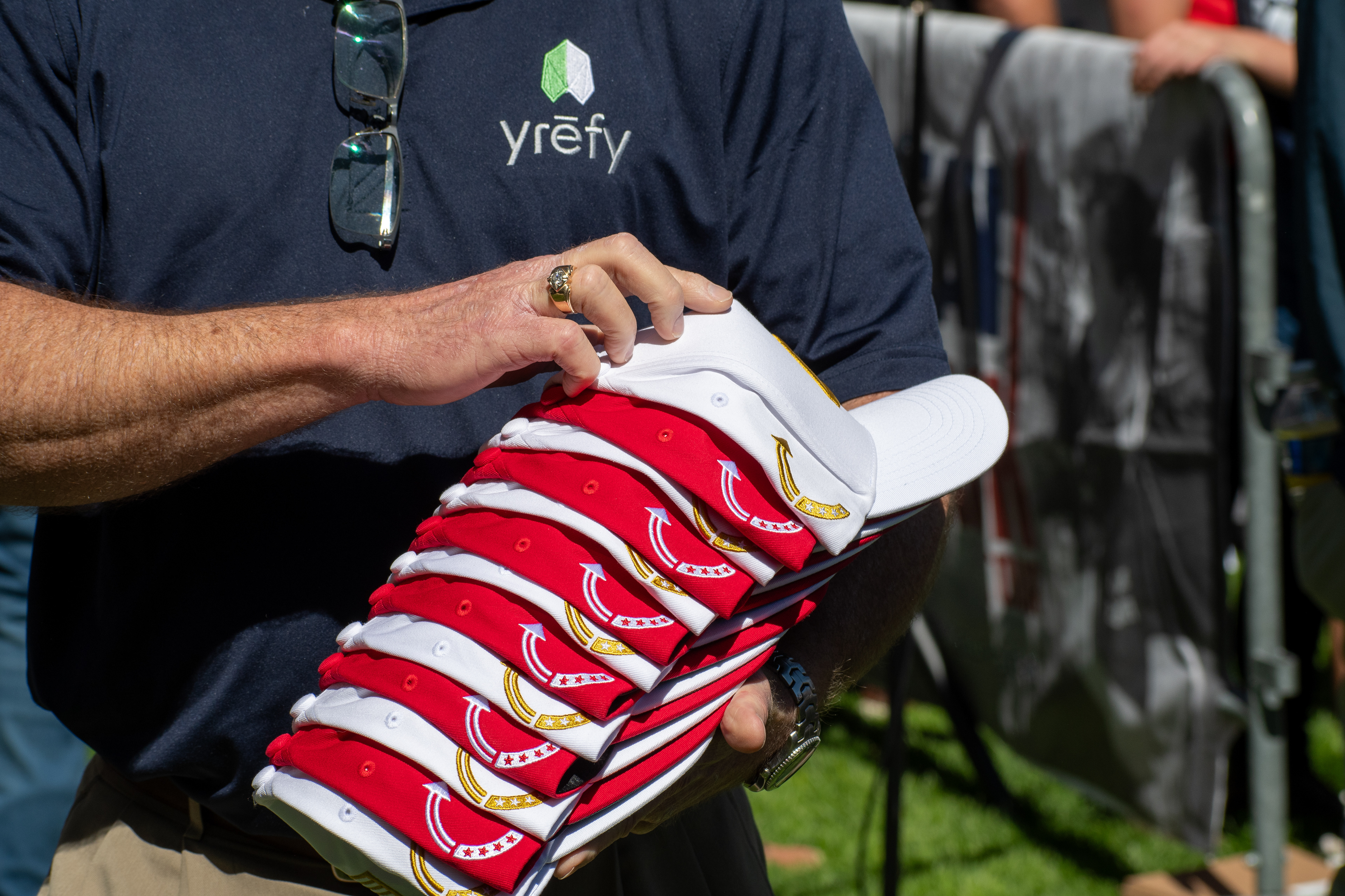 OREM, UTAH – SEPTEMBER 10, 2025: An event staffer organizes merchandise ahead of Charlie Kirk’s scheduled appearance at Utah Valley University. Holding a stack of red and white caps, the individual reflects the logistical coordination and quiet preparation that shaped the opening stop of the American Comeback Tour. The image captures a moment of order, presence, and behind-the-scenes engagement. © Charles-McClintock Wilson / ZUMA Press