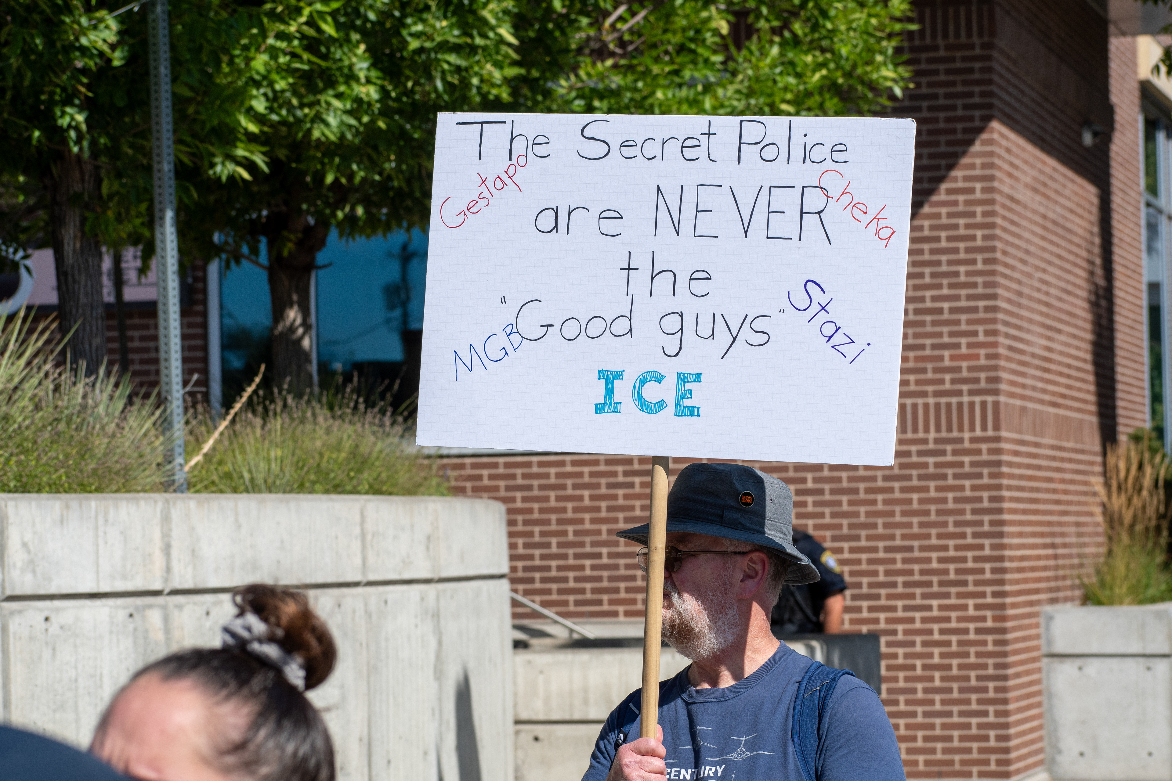 September 15, 2025 – Provo, Utah, United States: A demonstrator holds a sign comparing ICE to historical secret police organizations—including the Gestapo, Cheka, MGB, and Stasi—outside the Utah Valley Convention Center during a protest against the Department of Homeland Security career expo. The message asserts that “The Secret Police are NEVER the Good guys,” invoking historical critique and symbolic resistance. Photograph by Charles‑McClintock Wilson / ZUMA Press Wire