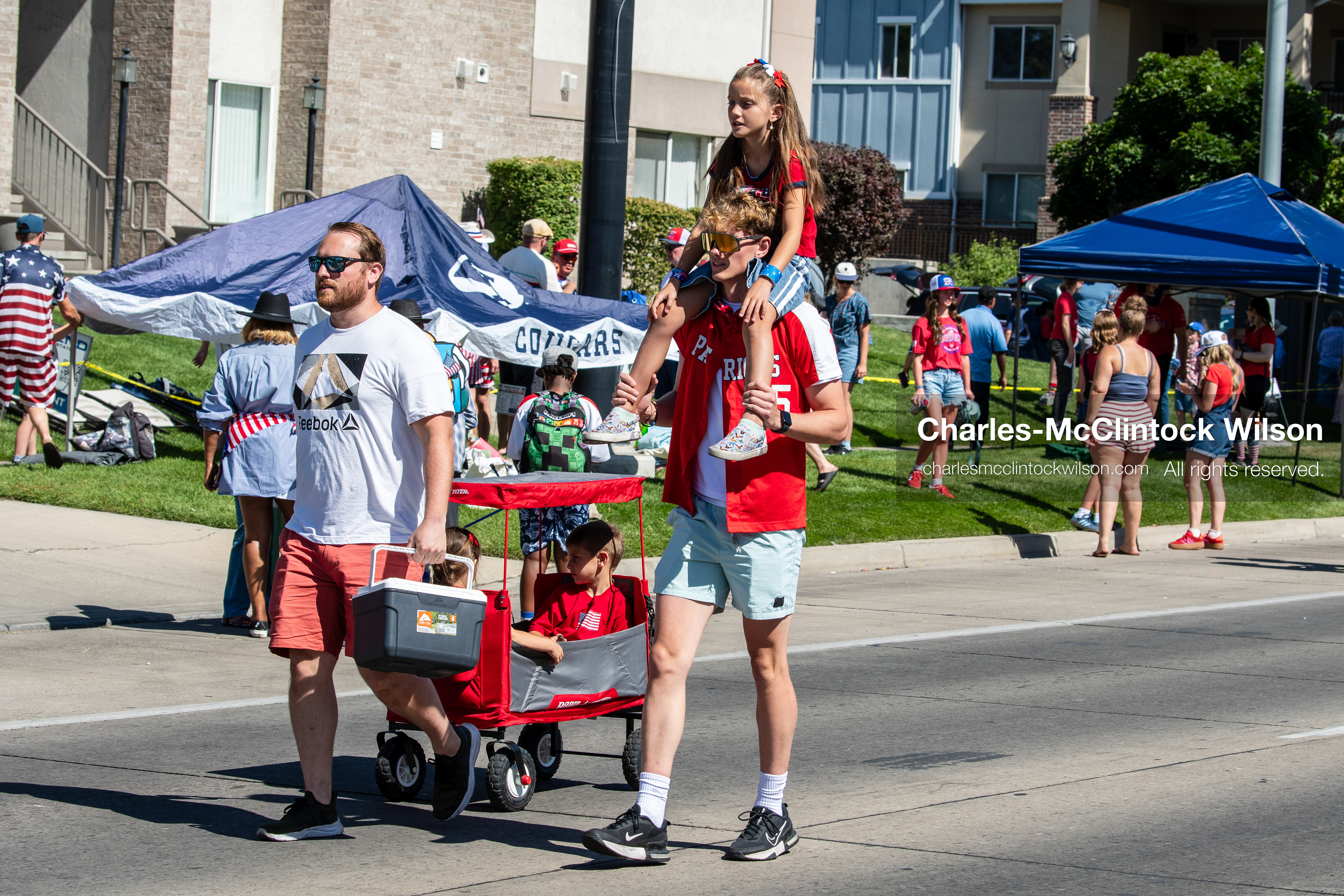 July 4, 2026, Provo, Utah, USA: Attendees pull a wagon containing a child along the side of the route during America's Freedom Festival Grand Parade in Provo, Utah, Saturday, July 4, 2026. The annual event drew thousands of spectators to the downtown corridor. (Credit Image: © Charles-McClintock Wilson/ZUMA Press Wire)