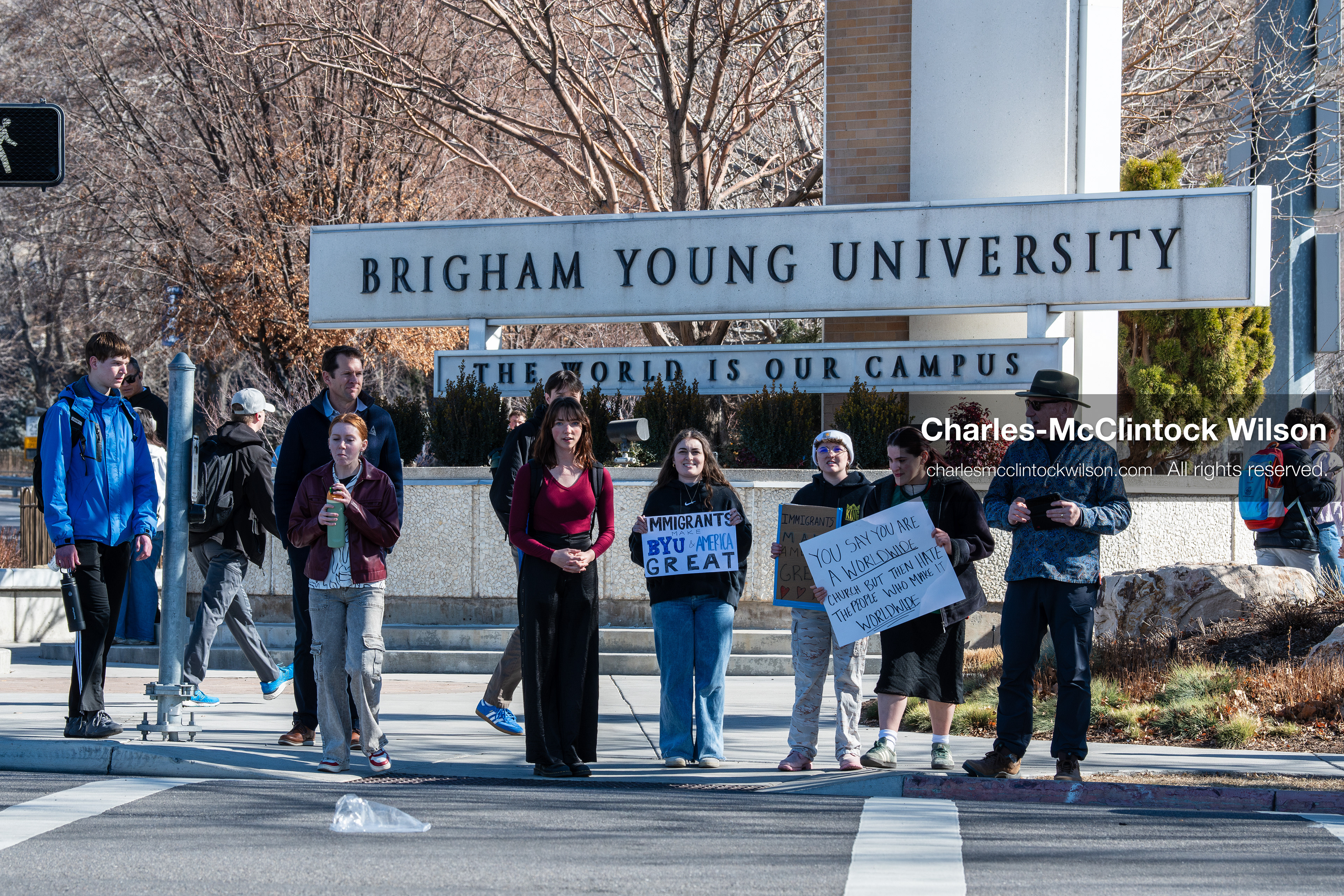 February 5, 2026, Provo, Utah, USA: People walk near the Brigham Young University entrance in Provo as demonstrators carrying signs gather to protest the presence of US Customs and Border Protection recruiters at a career fair held on the BYU campus. (Credit Image: © Charles McClintock Wilson/ZUMA Press Wire)