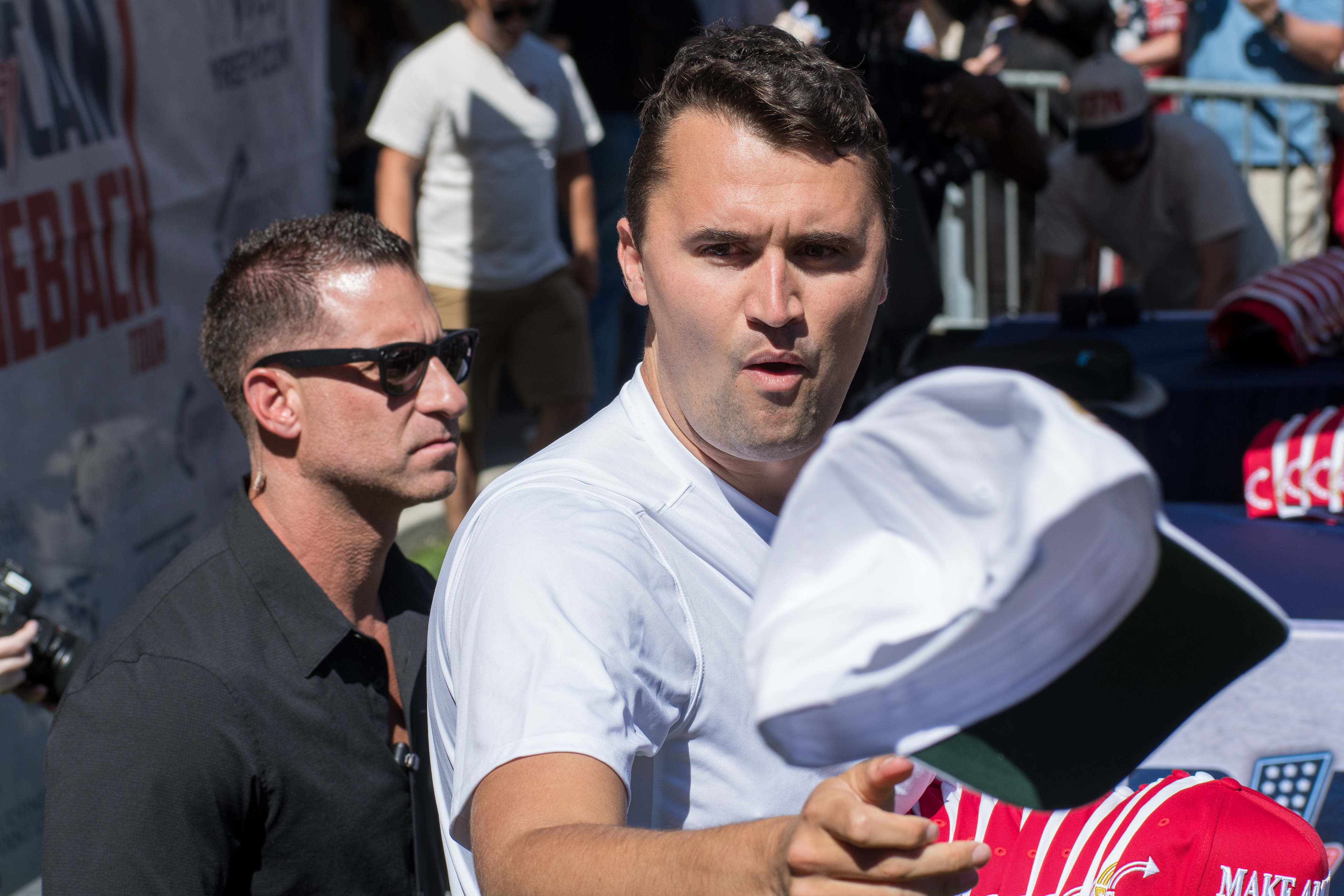 OREM, UTAH – SEPTEMBER 10, 2025: Charlie Kirk holds several “Make America Great Again” hats while interacting with supporters during a public event at Utah Valley University. Positioned near a merchandise table and surrounded by attendees, Kirk engages directly with the crowd in one of his final public moments. The image reflects the branding, outreach, and political symbolism that defined the gathering. © Charles-McClintock Wilson / ZUMA Press