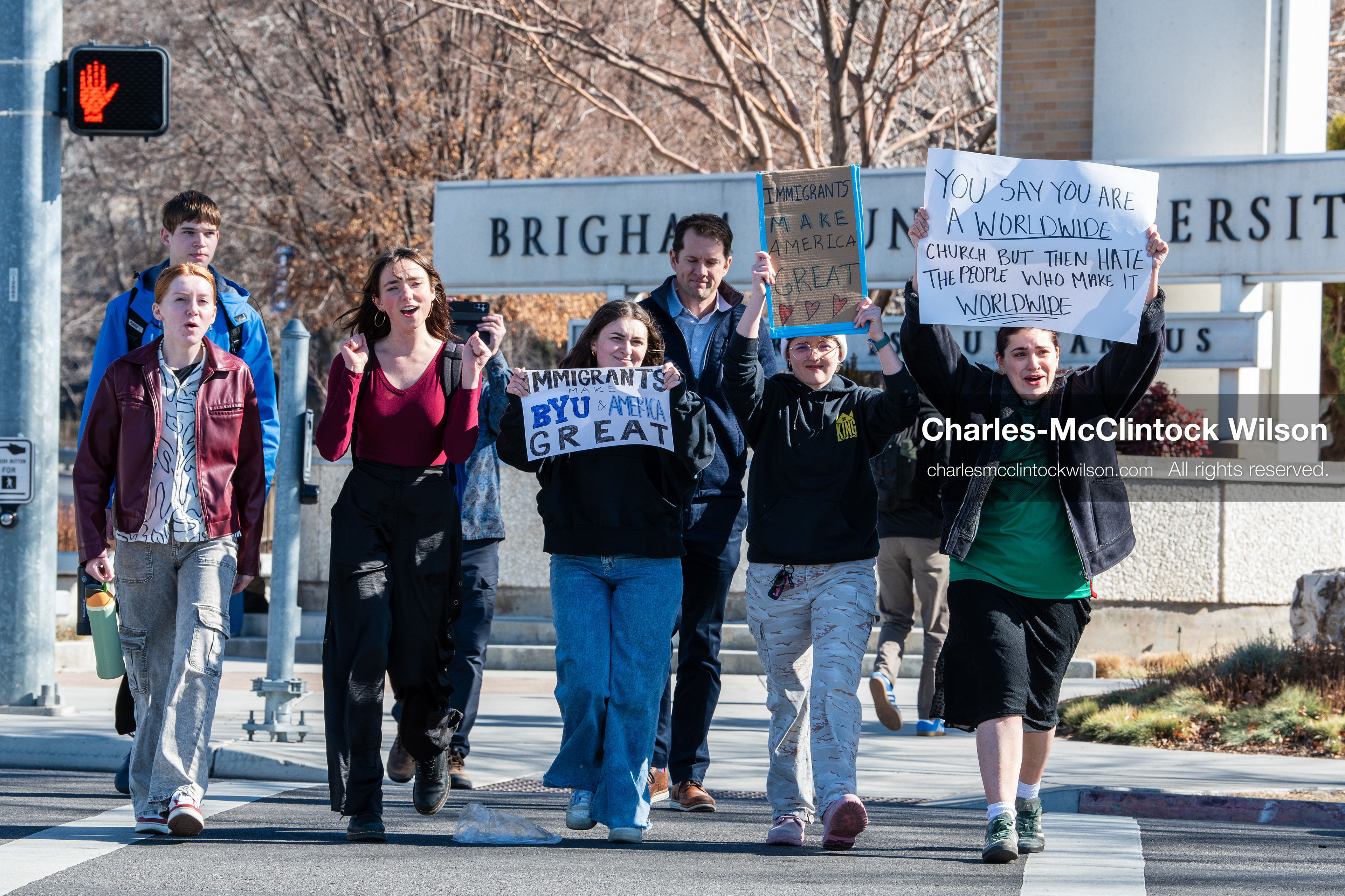 February 5, 2026, Provo, Utah, USA: People walk near the Brigham Young University entrance in Provo as demonstrators carrying signs gather to protest the presence of US Customs and Border Protection recruiters at a career fair held on the BYU campus. (Credit Image: © Charles McClintock Wilson/ZUMA Press Wire)