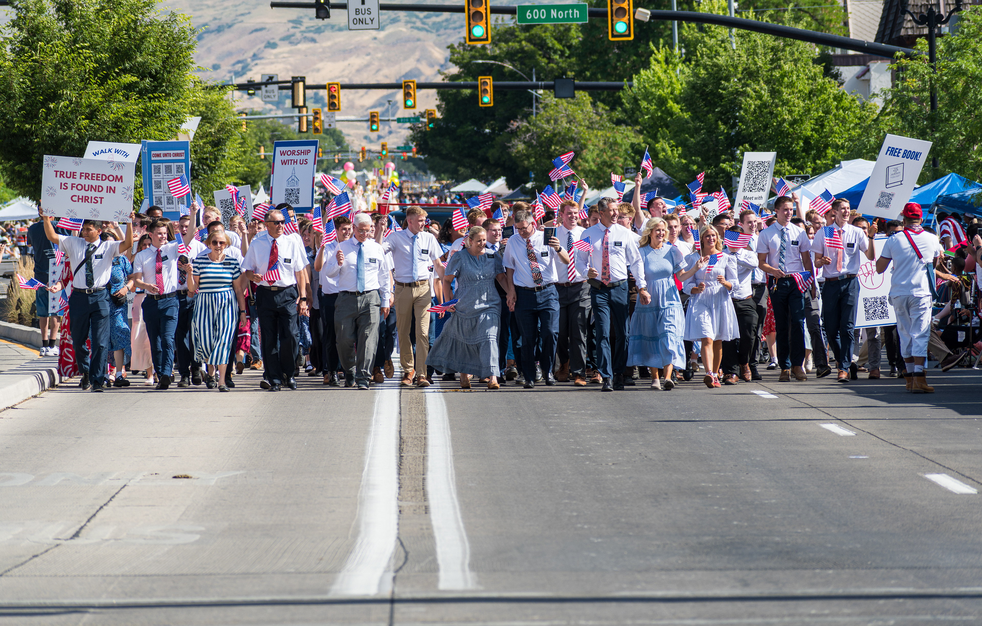 Provo, Utah - July 4, 2025: Members of The Church of Jesus Christ of Latter-day Saints march with U.S. flags and faith signs during the Freedom Festival Grand Parade in downtown Provo.