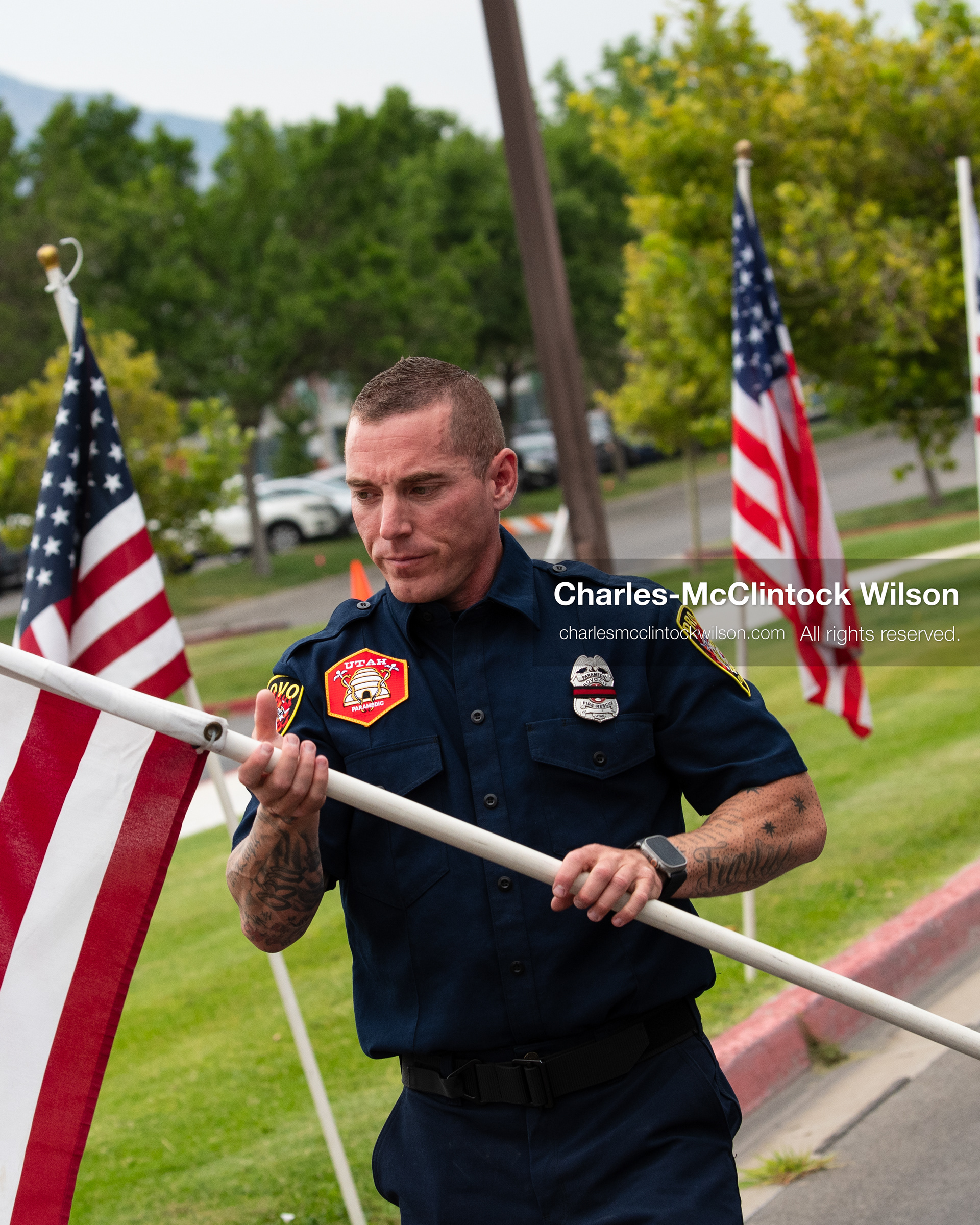 A firefighter adjusts an American flag along the perimeter walkway outside the UCCU Center at Utah Valley University in Orem, Utah, on Wednesday, July 29, 2026. Over 300 people attended the service for Captain Spencer Long, his wife, and three of their sons. (Photo by Charles-McClintock Wilson/Sipa USA)