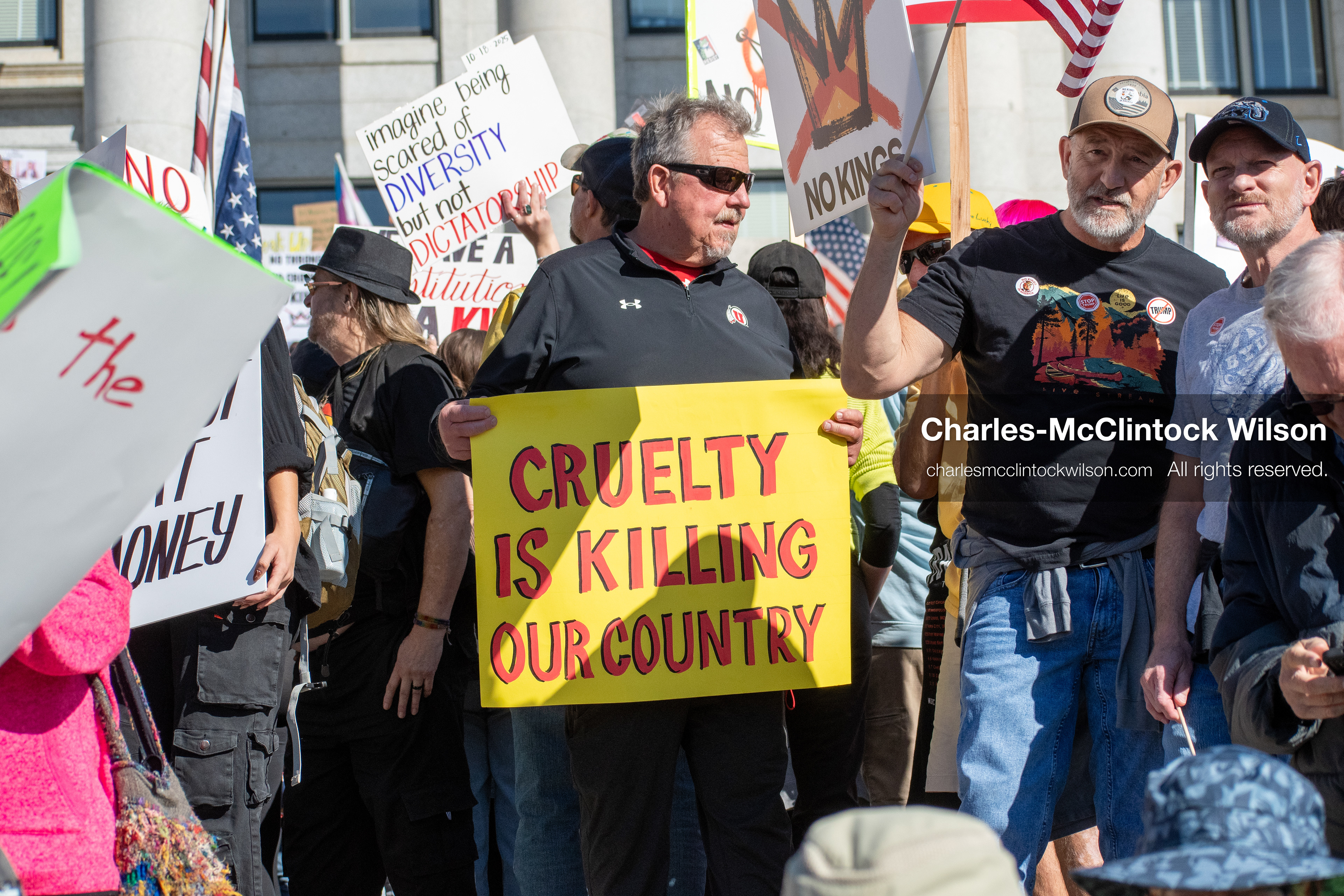 October 18, 2025, Salt Lake City, Utah, USA: Demonstrators gather on the steps of the Utah State Capitol during a "No Kings" protest held as part of a nationwide mobilization. Participants hold signs and flags while documenting the event. The protest was one of several organized across the United States.