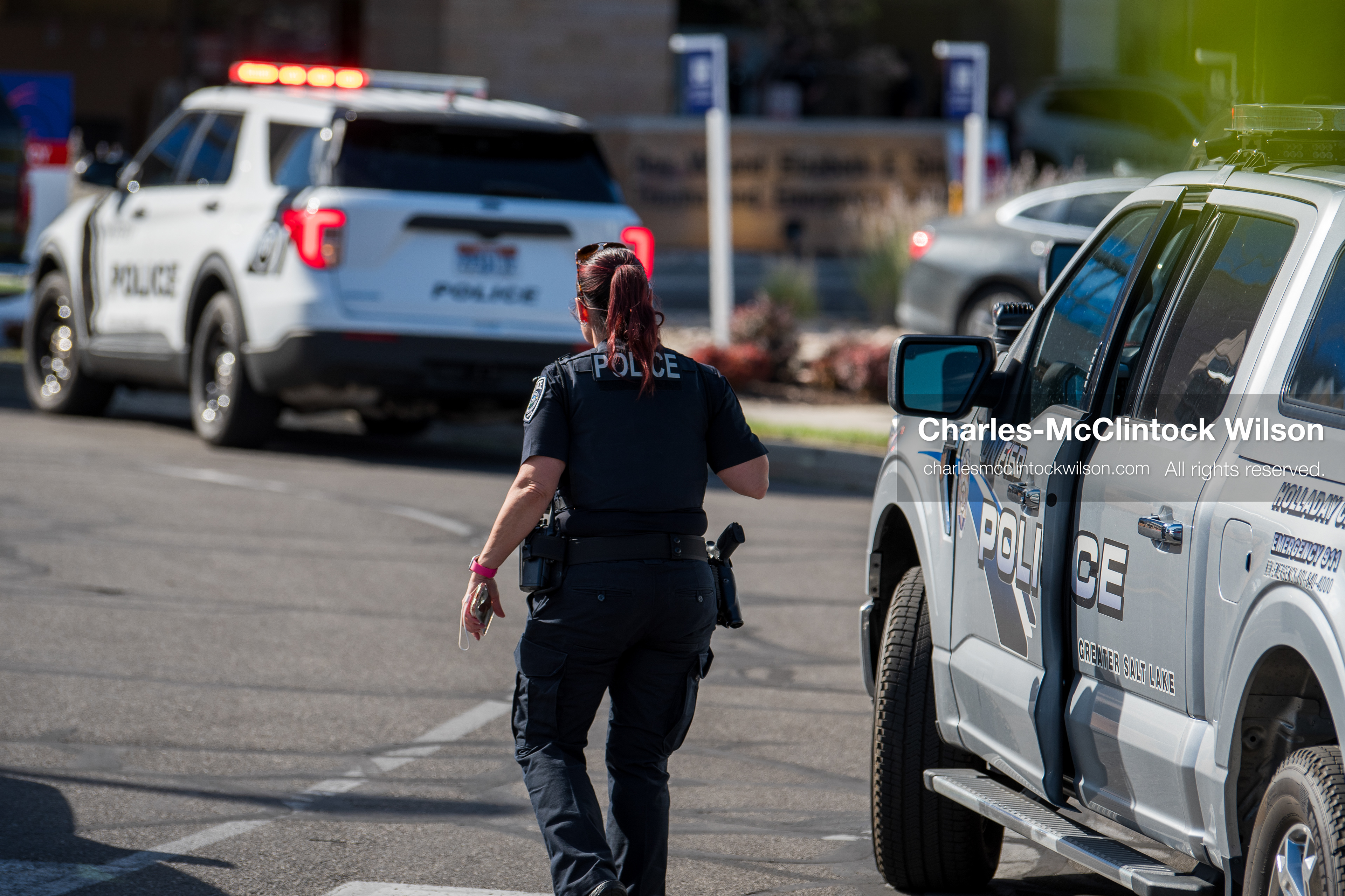 An armed law enforcement officer patrols a sidewalk perimeter outside Intermountain Medical Center in Murray, Utah, United States, on August 17, 2026. Multiple regional police agencies secured the hospital perimeter as a safety precaution after shooting victims were admitted following a fatal shootout outside a funeral service in nearby Kearns. (Photo by Charles-McClintock Wilson/NurPhoto)