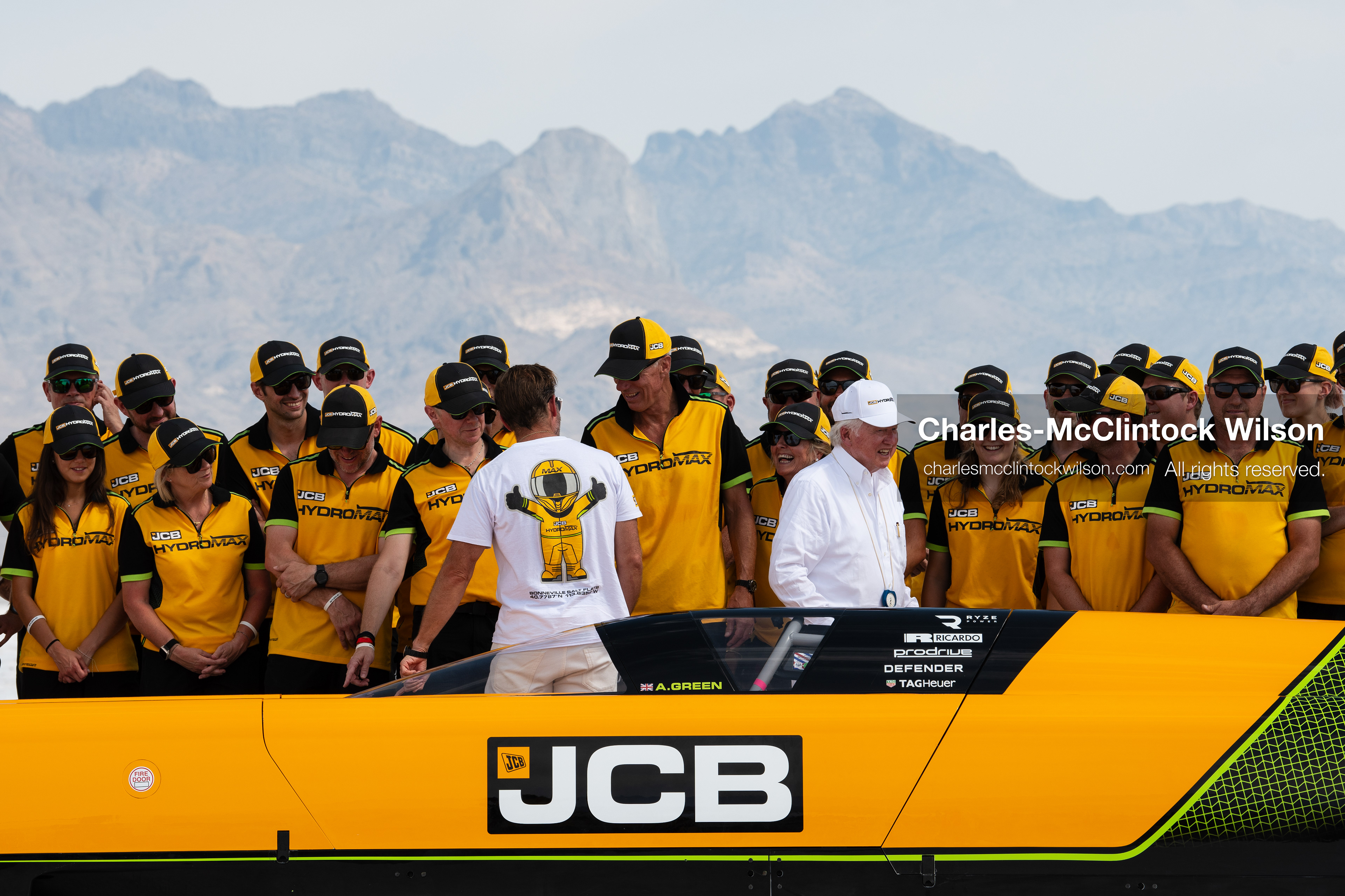 British pilot Andy Green and JCB Chairman Anthony Bamford converse with members of the JCB engineering team behind the cockpit of the "JCB Hydromax" on the Bonneville Salt Flats on Tuesday. The group gathered to celebrate setting a new hydrogen land speed record of 406.320 mph. (Photo by Charles-McClintock Wilson/Sipa USA)