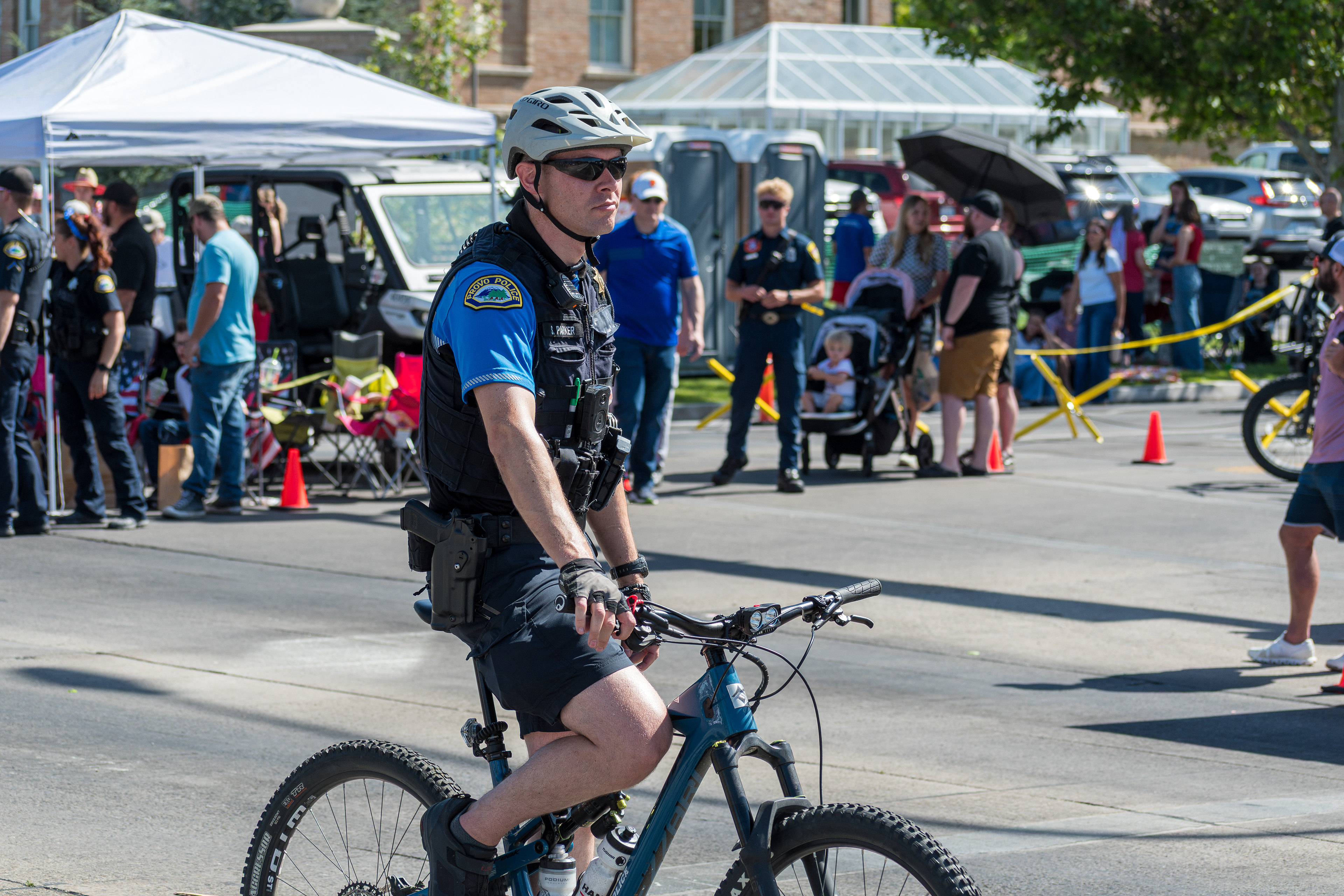 Provo, Utah – July 4, 2025: A police officer rides a bicycle along the parade route during the Freedom Festival Grand Parade, providing security and engaging with the community.