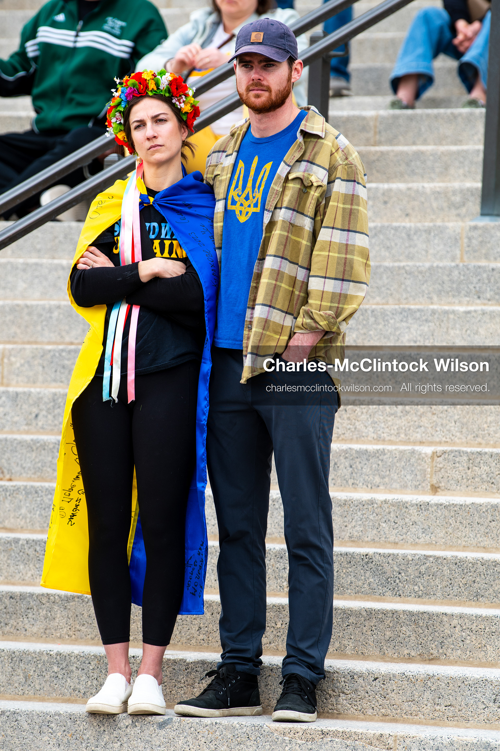 February 28, 2026, Salt Lake City, Utah, USA: Two demonstrators stand on the steps near the Utah State Capitol during the Stand With Ukraine rally, one wearing a blue and yellow cape with ribbons and a flower wreath, the other wearing a blue shirt with the Ukrainian trident. The gathering marked the four year anniversary of the full scale Russian invasion of Ukraine and brought community members together in support of Ukrainians and local humanitarian efforts. (Credit Image: © Charles McClintock Wilson/ZUMA Press Wire)