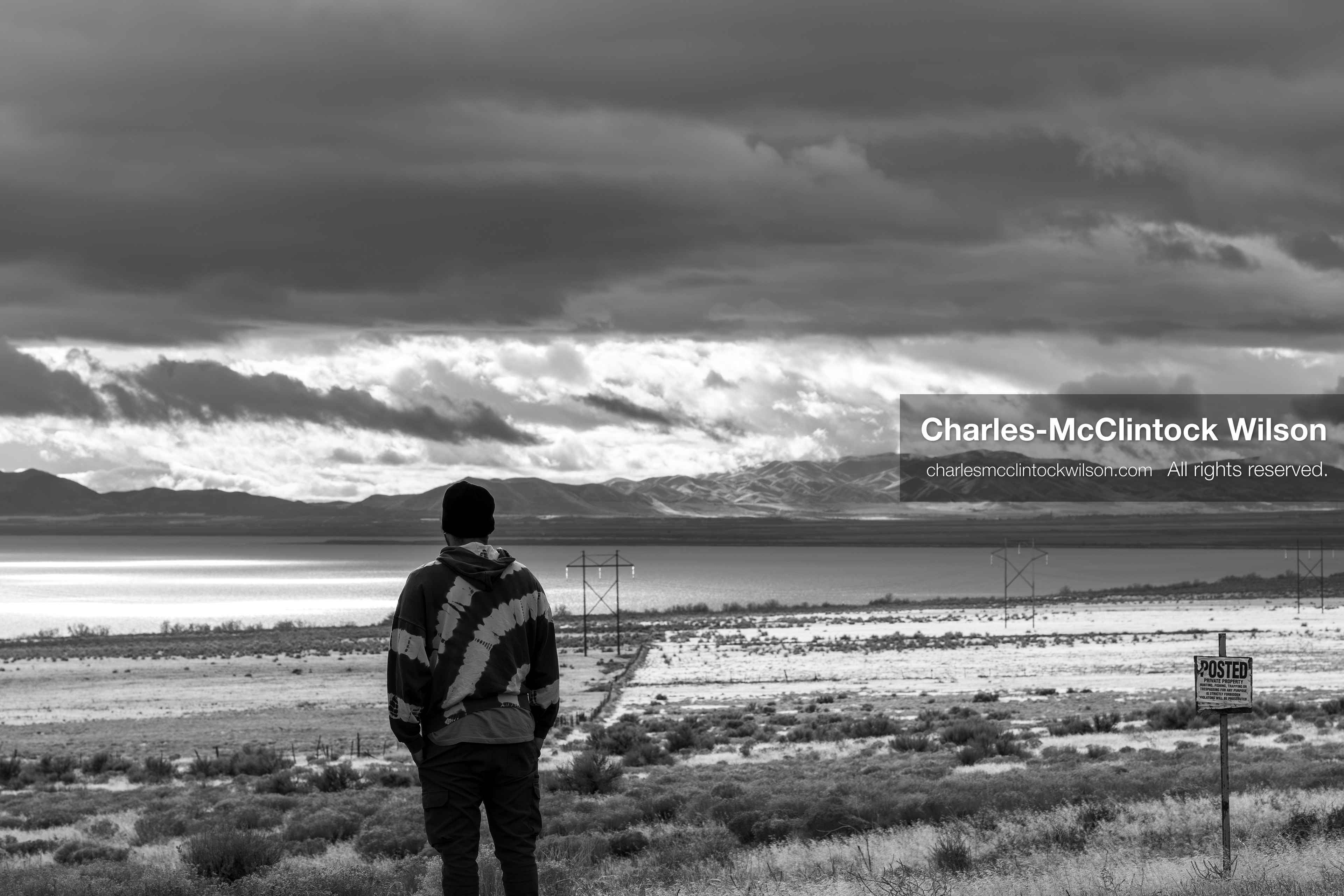 January 1, 2026, Saratoga Springs, Utah, USA: A man stands near a posted sign overlooking Utah Lake on January 1, 2026, in Saratoga Springs, Utah, USA. Power lines stretch across dry terrain as dramatic clouds gather over the lake and distant mountains. (Credit Image: © Charles-McClintock Wilson/ZUMA Press Wire)