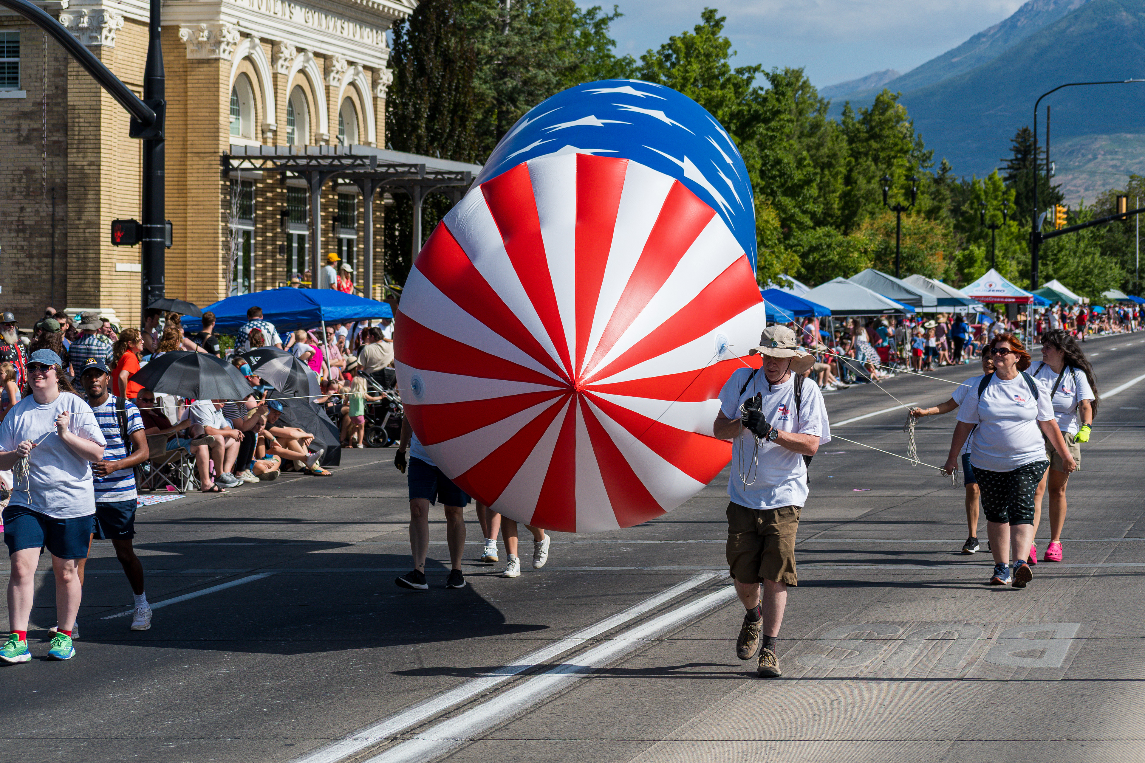 Provo, Utah – July 4, 2025: Participants guide a helium parade balloon decorated with the U.S. flag during the Freedom Festival Grand Parade in downtown Provo.