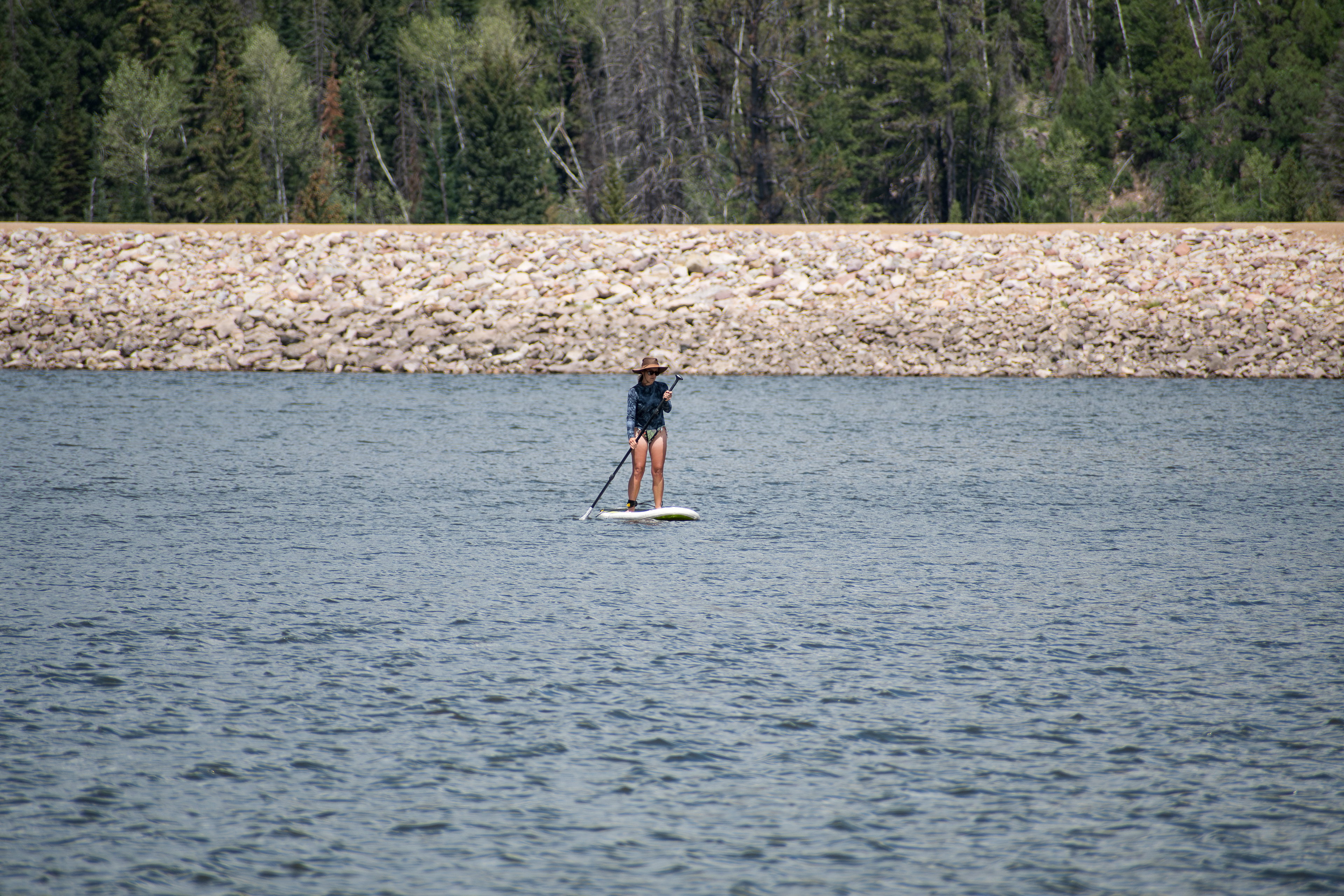 Summit County, Utah – July 20, 2025: A woman paddleboards across the water at Smith and Morehouse Reservoir. 