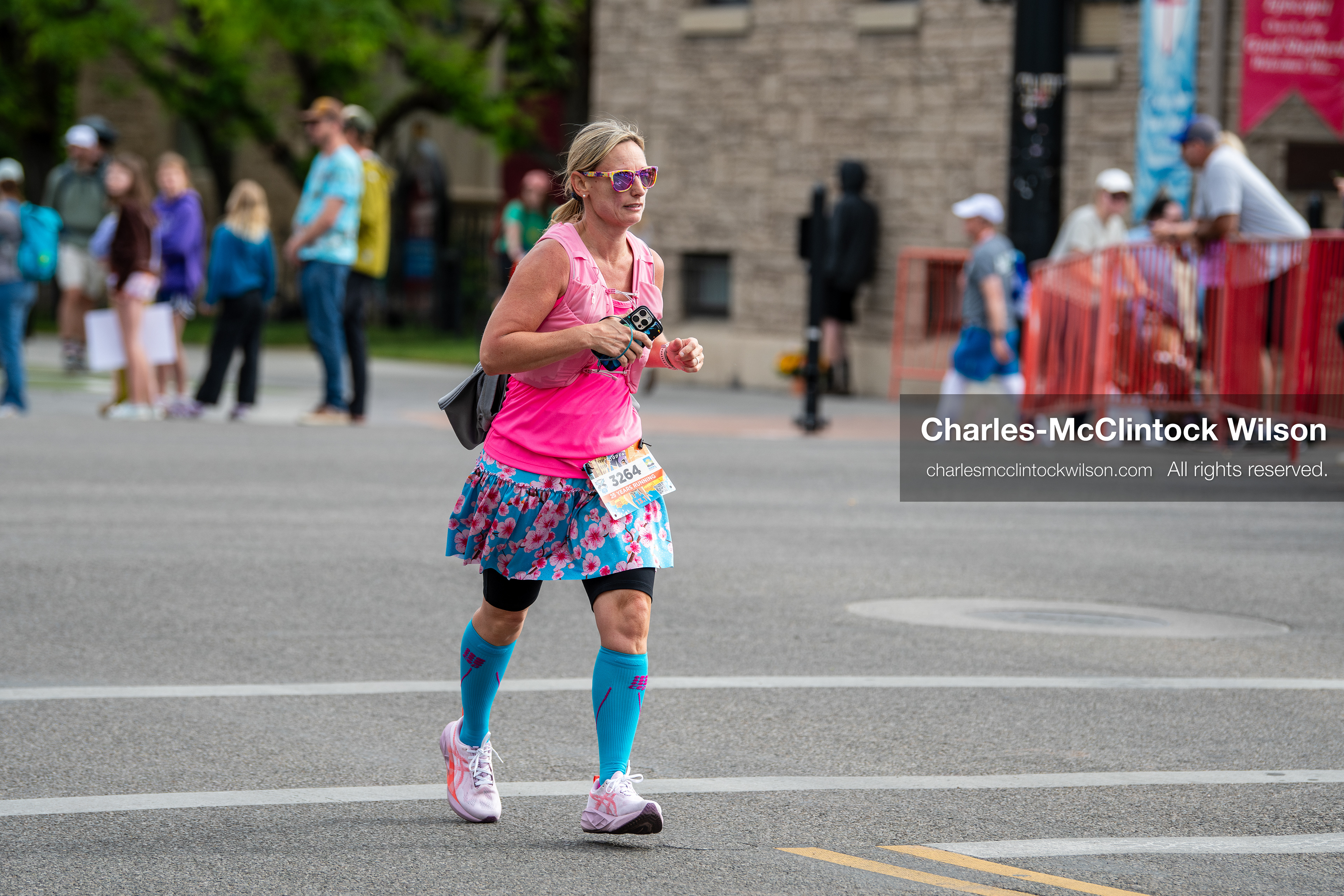 May 16, 2026, Ogden, Utah, USA: A runner wearing a bright pink top and patterned skirt competes in the 25th Annual America First Ogden Marathon in Ogden, Utah, on Saturday, May 16, 2026. Spectators line the course behind barricades as participants make their way through downtown streets during the milestone 25th running of the event. (Credit Image: © Charles-McClintock Wilson/ZUMA Press Wire)