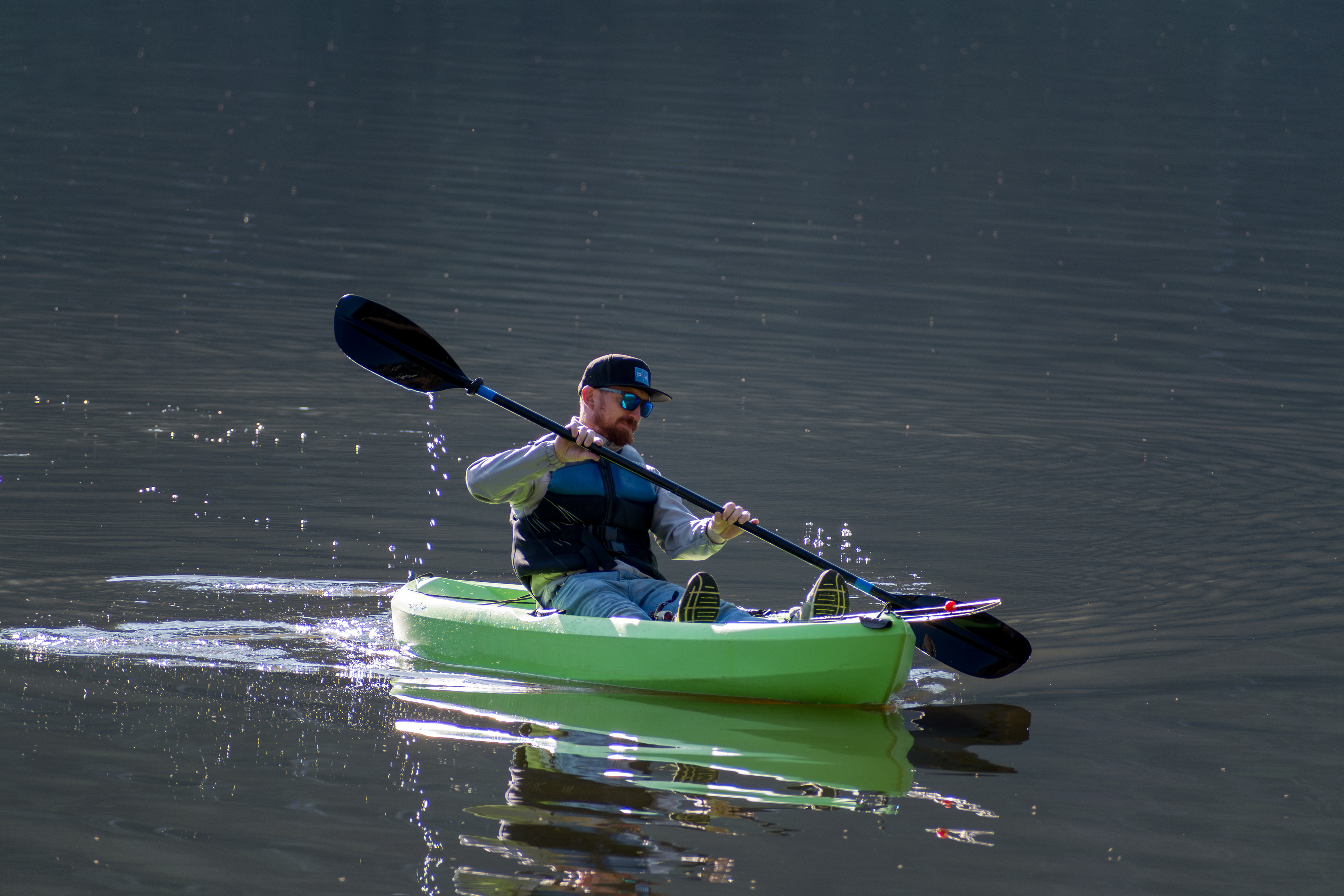 Summit County, Utah – July 20, 2025: A man paddles a bright green kayak while fishing at Smith and Morehouse Reservoir.