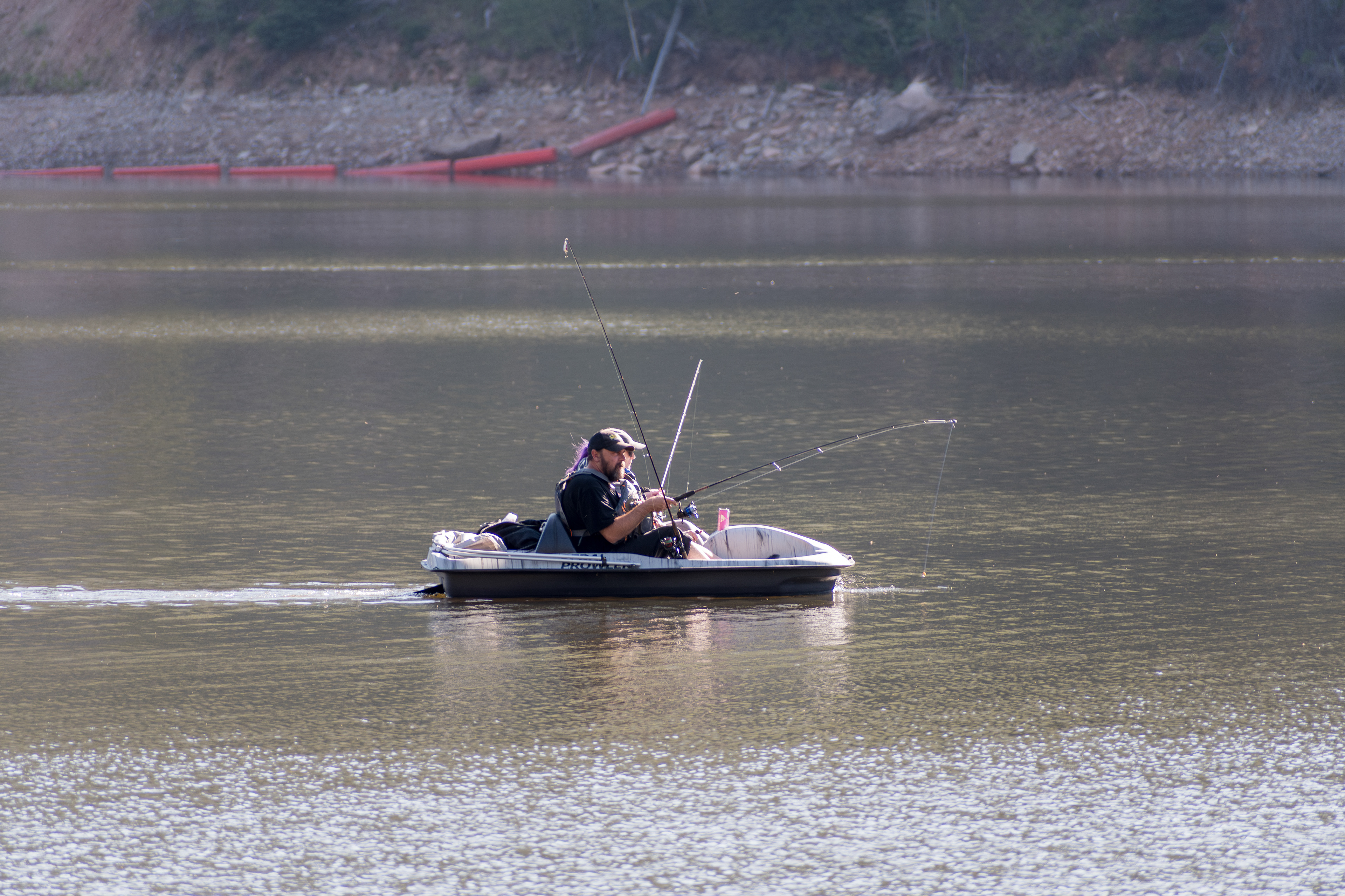 Summit County, Utah – July 20, 2025: People fish from a pedal boat on the calm waters of Smith and Morehouse Reservoir during a summer outing.