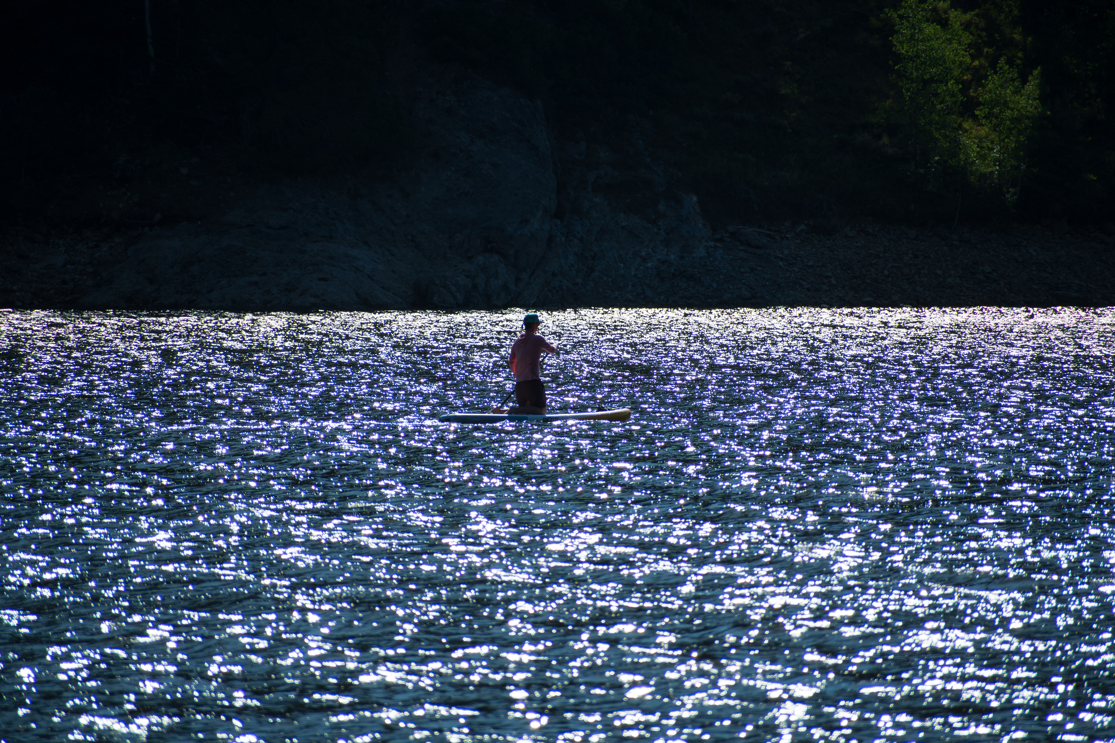 Summit County, Utah – July 20, 2025: A man paddleboards across the water at Smith and Morehouse Reservoir. 