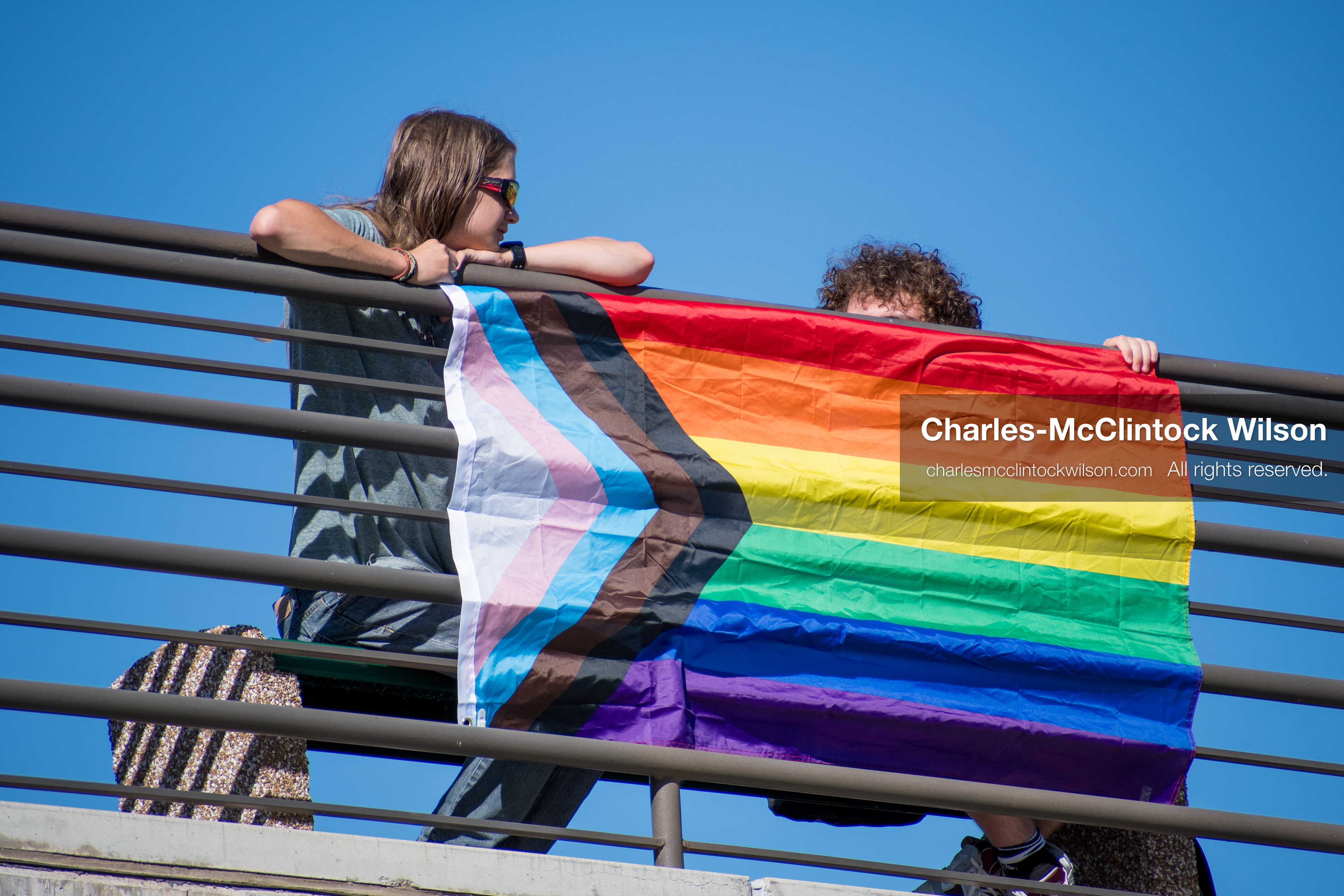 September 10, 2025, Orem, Utah, USA: A group of individuals stand atop the Fountain Courtyard at Utah Valley University, holding a Progress Pride flag during conservative activist Charlie Kirk’s American Comeback Tour appearance. The event drew over 3,000 attendees and was marked by heightened civic tension and symbolic gestures from both supporters and critics. Kirk was fatally shot moments later during the public Q&A session, prompting national scrutiny of campus security protocols and institutional response. (Credit Image: © Charles‑McClintock Wilson/ZUMA Press Wire)