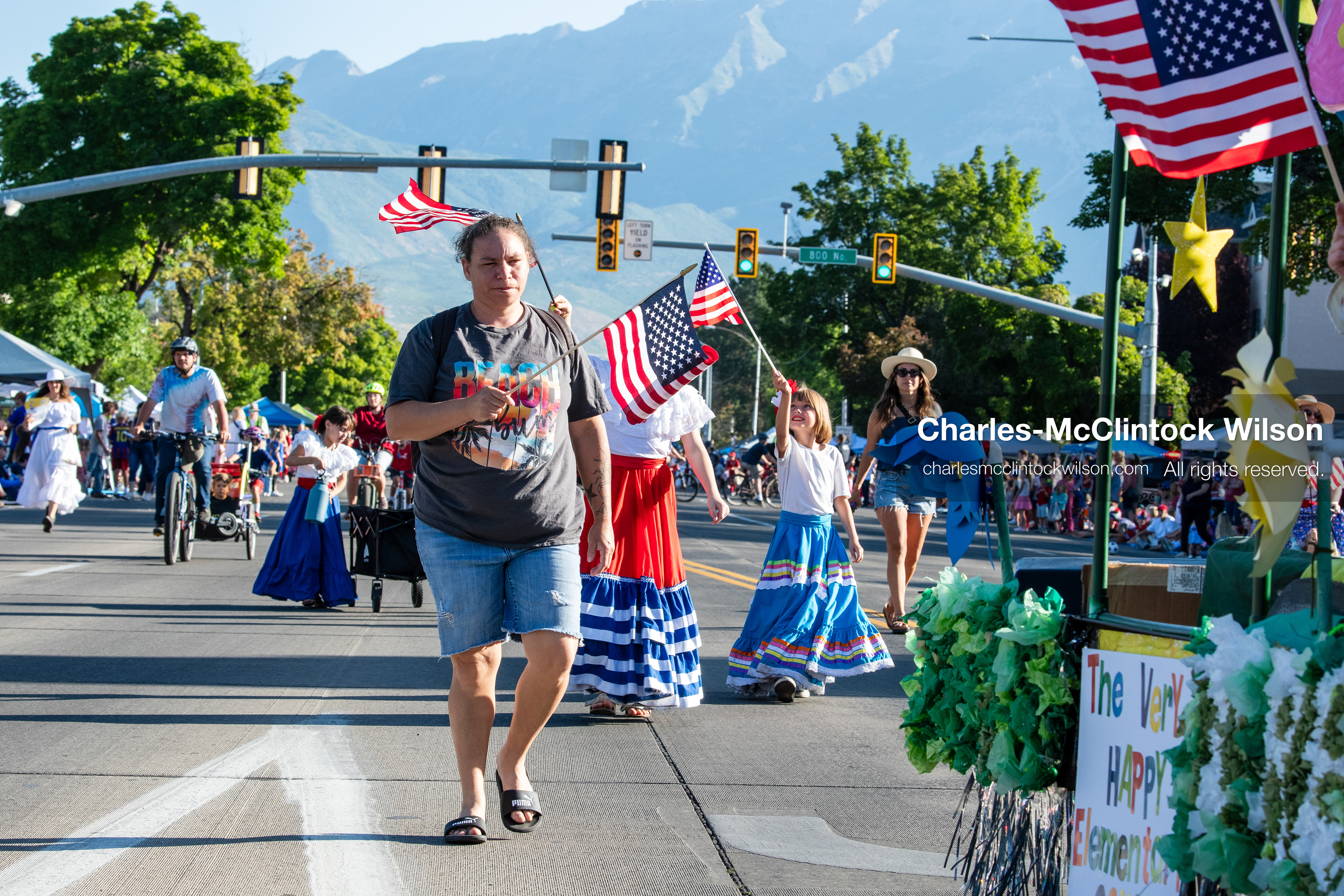 July 4, 2026, Provo, Utah, USA: A woman walks down the street ahead of parade participants wearing traditional folk skirts and waving American flags during America's Freedom Festival Grand Parade in Provo, Utah, Saturday, July 4, 2026. The annual Independence Day event features expanded programming to honor the 250th anniversary of United States independence. (Credit Image: © Charles-McClintock Wilson/ZUMA Press Wire)