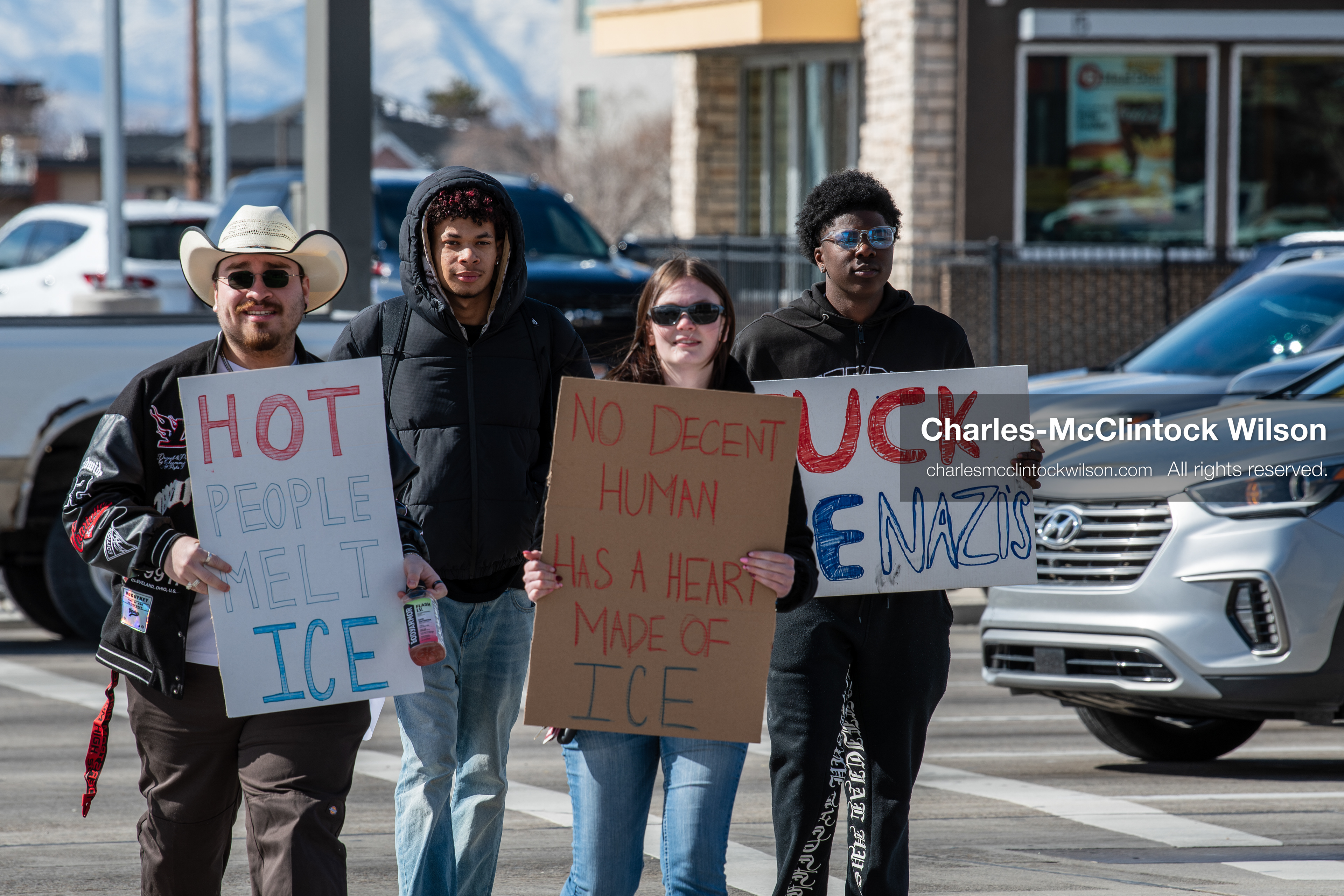 February 20, 2026, Orem, Utah, USA: Participants stand at a street corner during a student led protest against ICE in front of Orem City Hall. One carries a flag while another holds a sign as vehicles pass through the area. (Credit Image: © Charles McClintock Wilson/ZUMA Press Wire)
