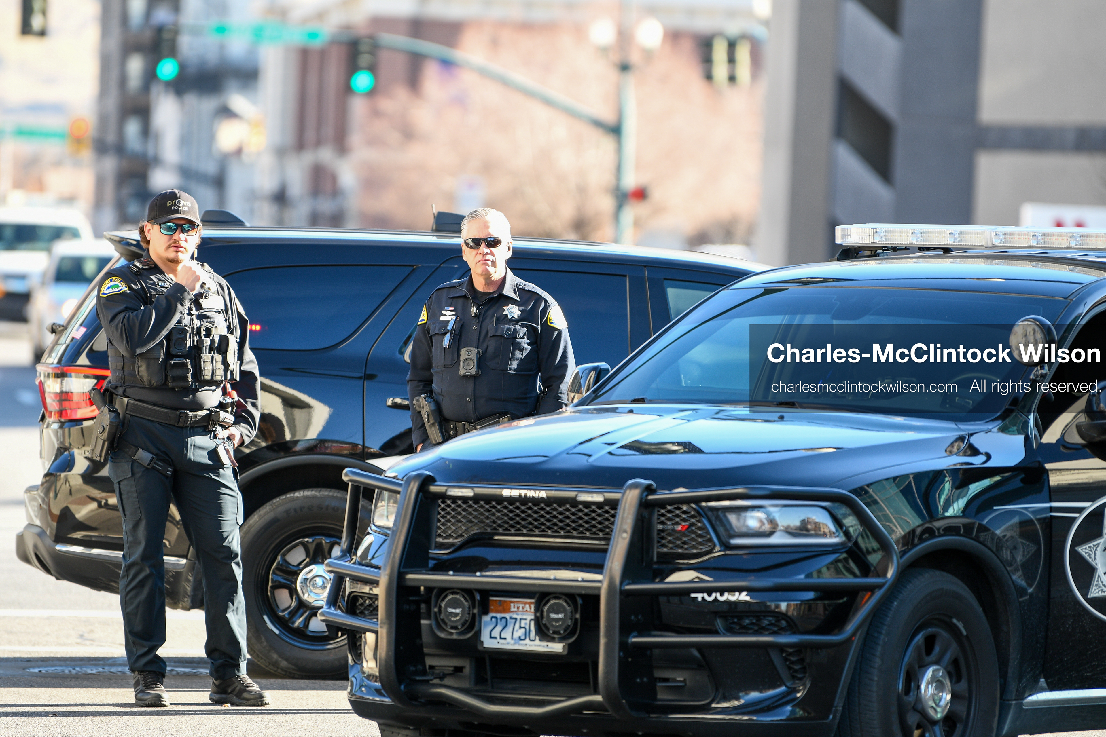 PROVO, UTAH, USA – DECEMBER 11, 2025: Two Provo Police officers block traffic near patrol vehicles outside the Fourth District Court in Provo during the first in‑person court appearance of Tyler Robinson in the Charlie Kirk murder case. (Credit Image: © Charles‑McClintock Wilson/ZUMA Press Wire)