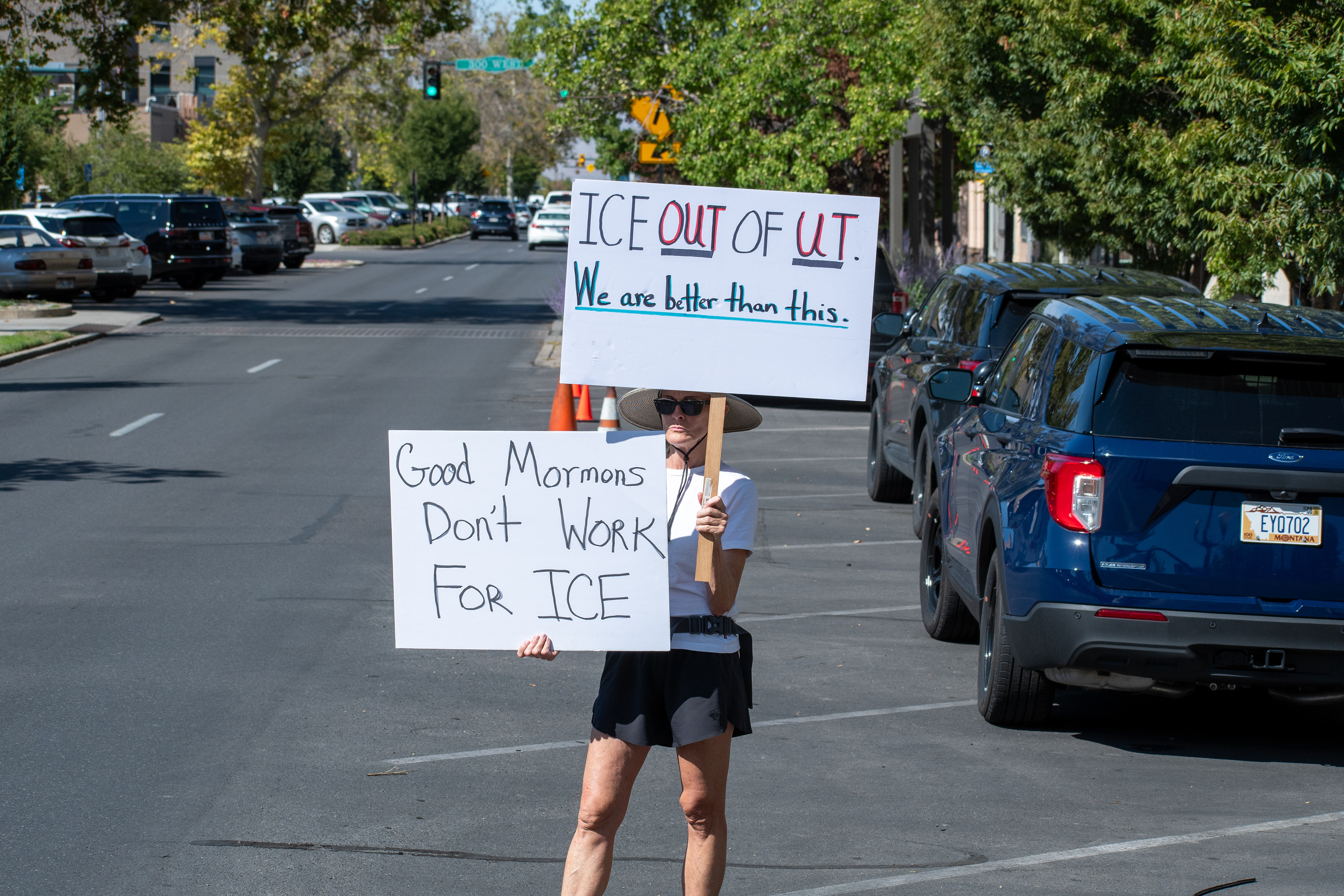 September 15, 2025 – Provo, Utah, United States: A demonstrator holds two signs outside the Utah Valley Convention Center during a protest against the Department of Homeland Security career expo. One sign reads “ICE OUT OF UT. We are better than this,” while the other declares “Good Mormons Don’t Work FOR ICE,” invoking regional identity and ethical critique. Photograph by Charles‑McClintock Wilson / ZUMA Press Wire
