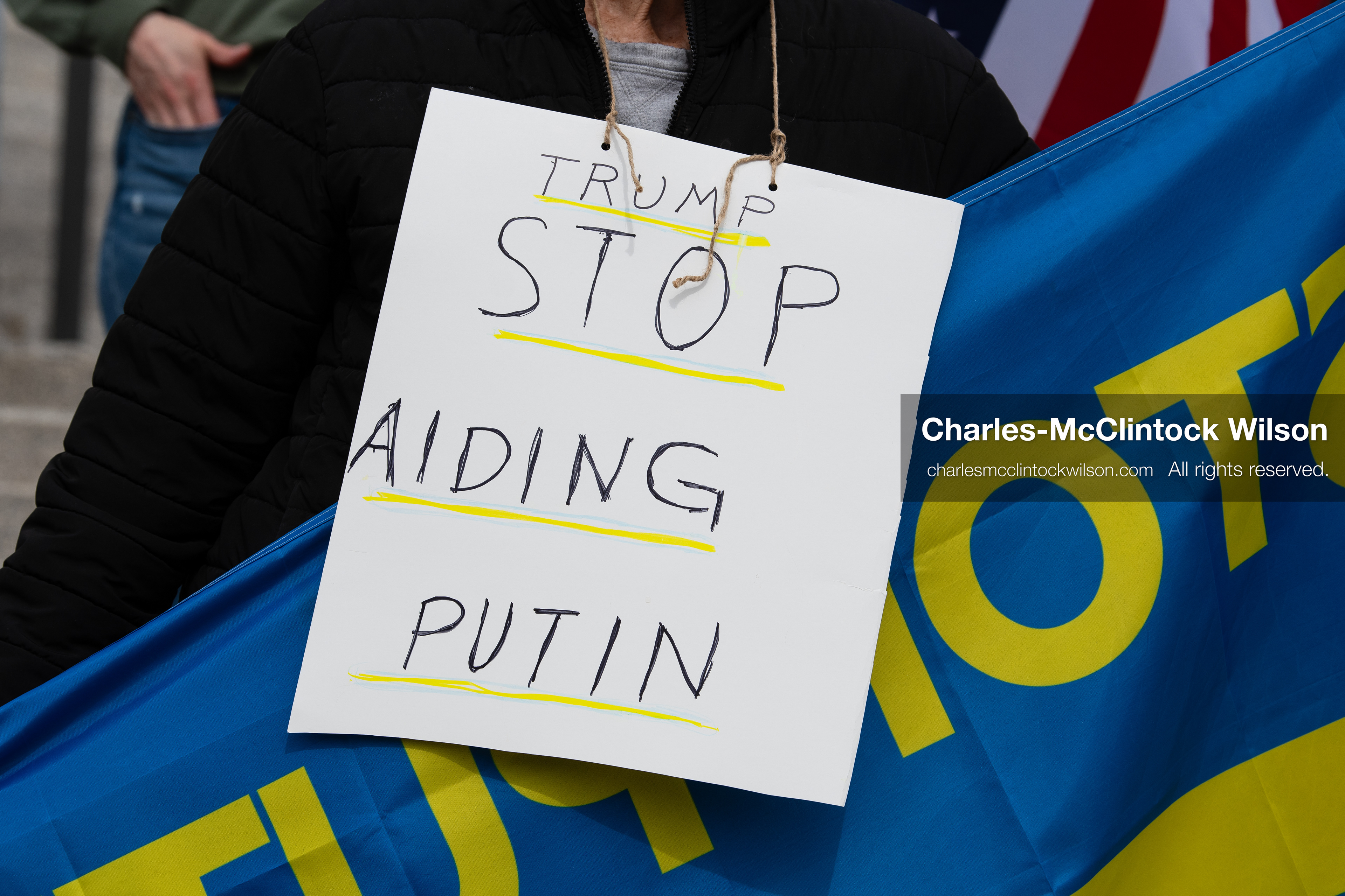 February 28, 2026, Salt Lake City, Utah, USA: A demonstrator wears a sign reading Trump Stop Aiding Putin during the Stand With Ukraine rally at the Utah State Capitol. The gathering marked the four year anniversary of the full scale Russian invasion of Ukraine and brought community members together in support of Ukrainians and local humanitarian efforts. (Credit Image: © Charles McClintock Wilson/ZUMA Press Wire)