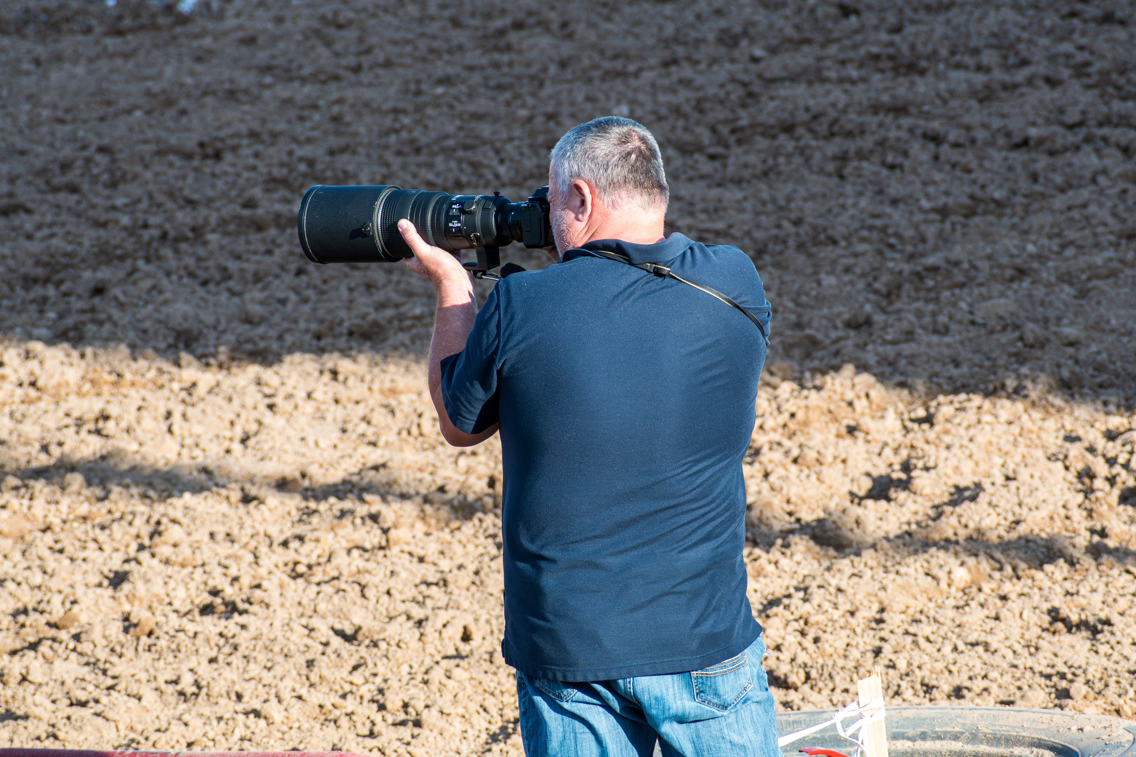 June 28, 2025 – Nephi, Utah: A photographer takes photos of motocross riders from the edge of the dirt arena during the Juab Xtreme Racing event.