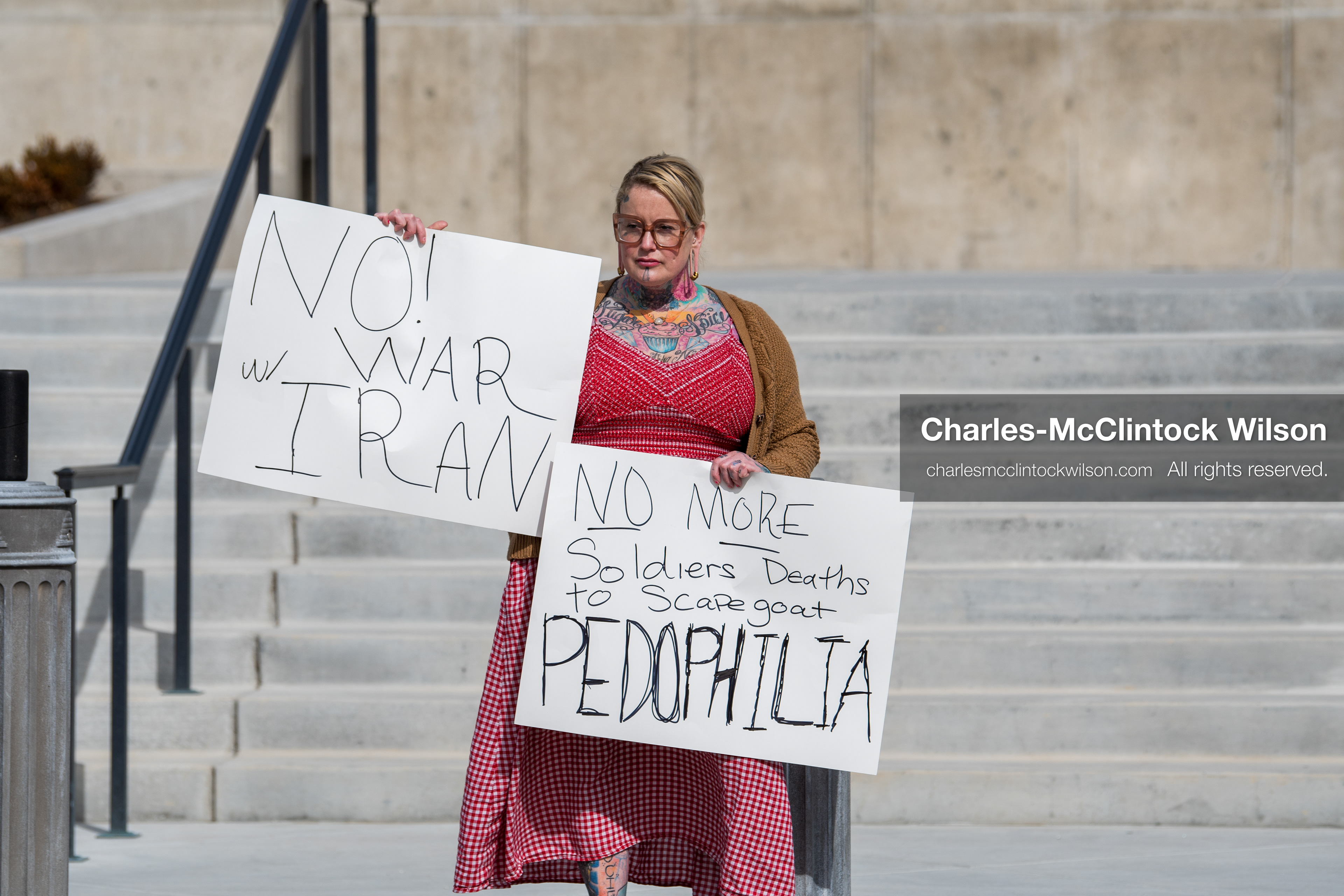 February 28, 2026, Salt Lake City, Utah, USA: A demonstrator stands on the steps of the Utah State Capitol holding two handwritten protest signs during the Stand With Ukraine rally. The gathering marked the four year anniversary of the full scale Russian invasion of Ukraine and brought community members together in support of Ukrainians and local humanitarian efforts. (Credit Image: © Charles McClintock Wilson/ZUMA Press Wire)