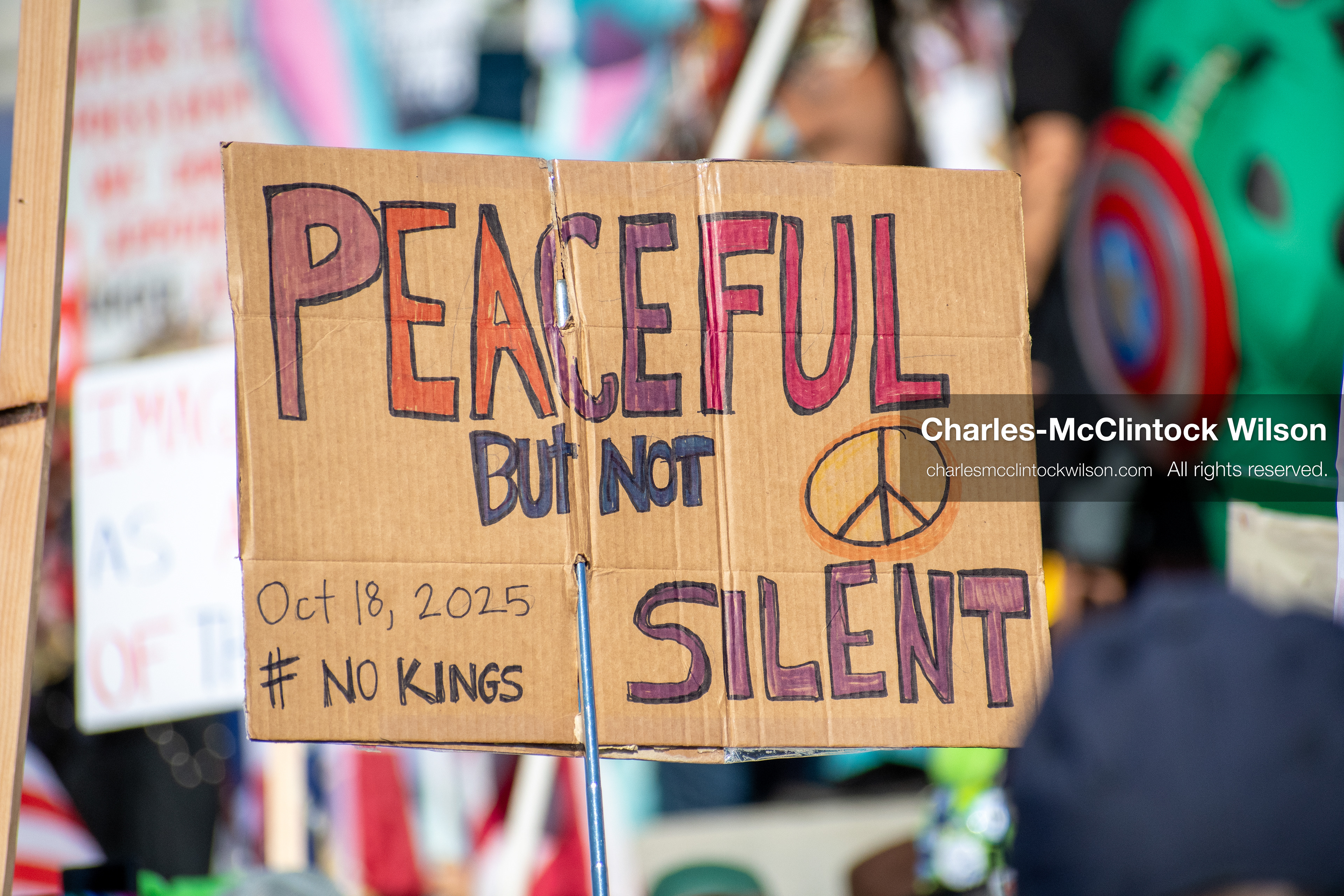 October 18, 2025, Salt Lake City, Utah, USA: A demonstrator raises a placard during a "No Kings" protest held at the Utah State Capitol. Other participants and signs are visible in the background during the public gathering.