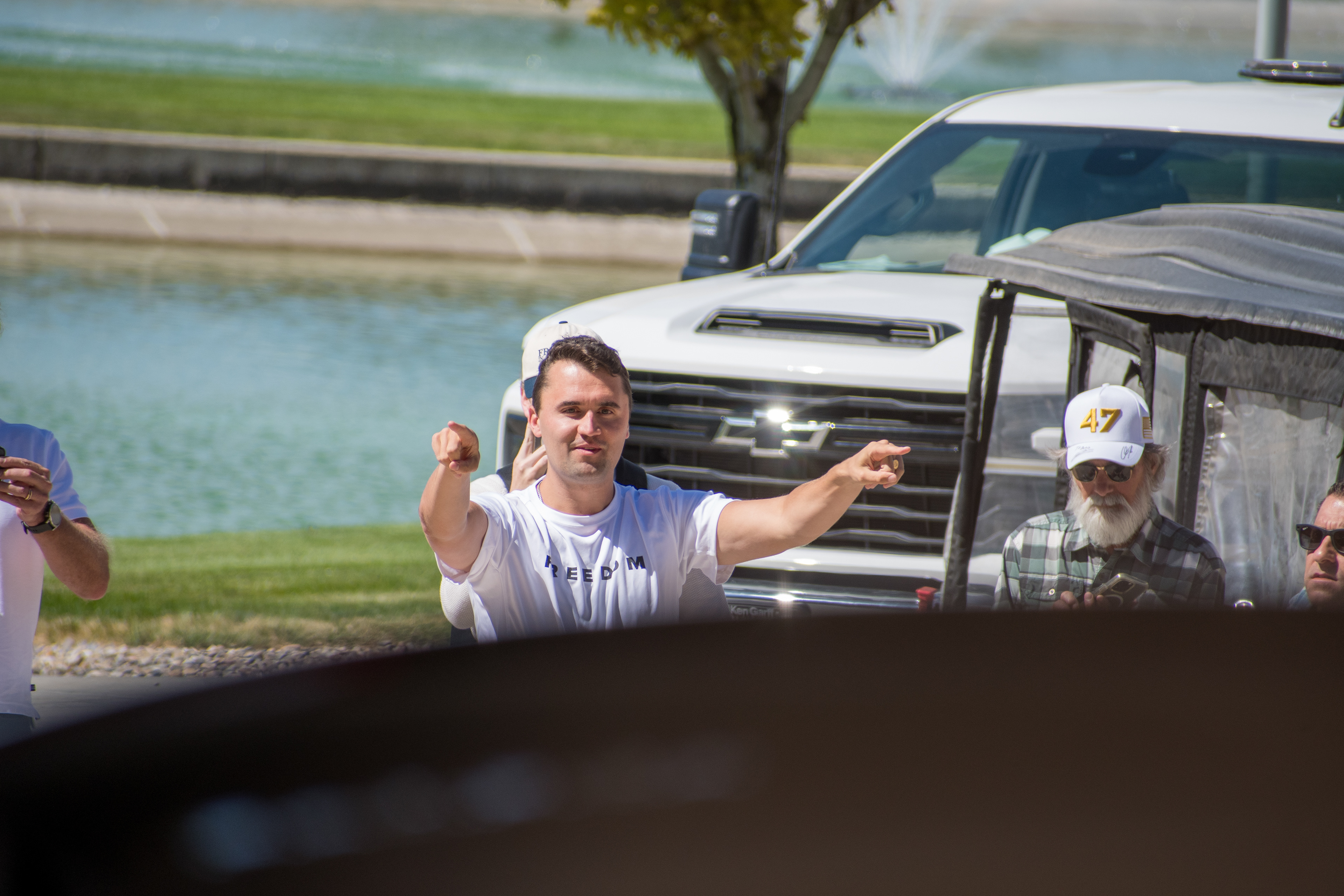 OREM, UTAH – SEPTEMBER 10, 2025: Charlie Kirk gestures while arriving at Utah Valley University for a scheduled public event. Surrounded by supporters and staff near a park-like setting, Kirk points toward the crowd in a moment of expressive engagement. The image marks the beginning of his final public appearance, reflecting anticipation, outreach, and symbolic presence. © Charles-McClintock Wilson / ZUMA Press