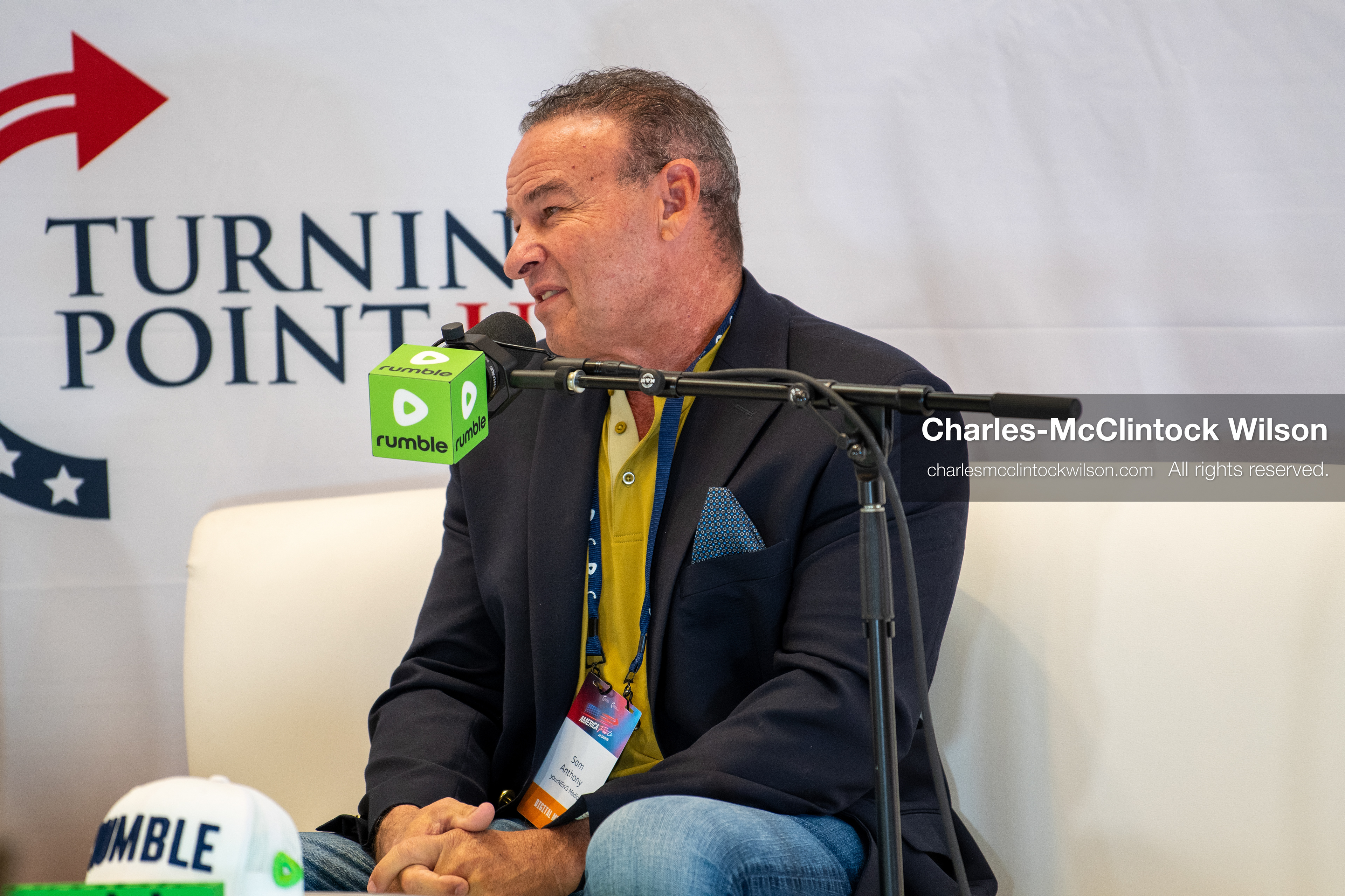December 18, 2025, Phoenix, Arizona, USA: Sam Anthony, founder, president, and CEO of YourNews, speaks during a media segment at AmericaFest 2025, seated beneath Turning Point USA branding and a Rumble microphone cube. (Credit Image: (c) Charles-McClintock Wilson/ZUMA Press Wire)