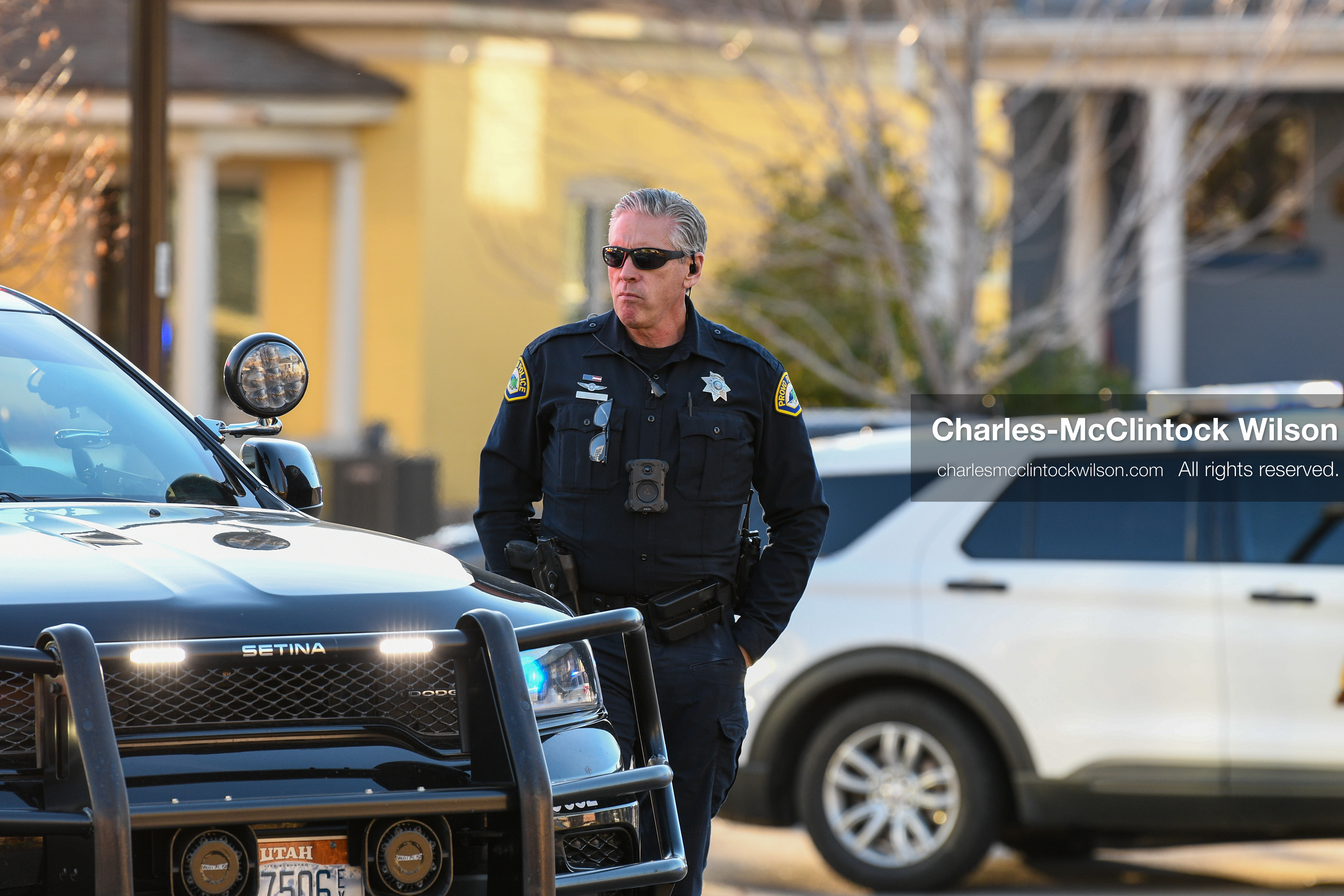 PROVO, UTAH, USA – DECEMBER 11, 2025: A Provo Police officer stands beside a patrol vehicle in a residential neighborhood near the Fourth District Court in Provo during the first in‑person court appearance of Tyler Robinson in the Charlie Kirk murder case. (Credit Image: © Charles‑McClintock Wilson/ZUMA Press Wire)