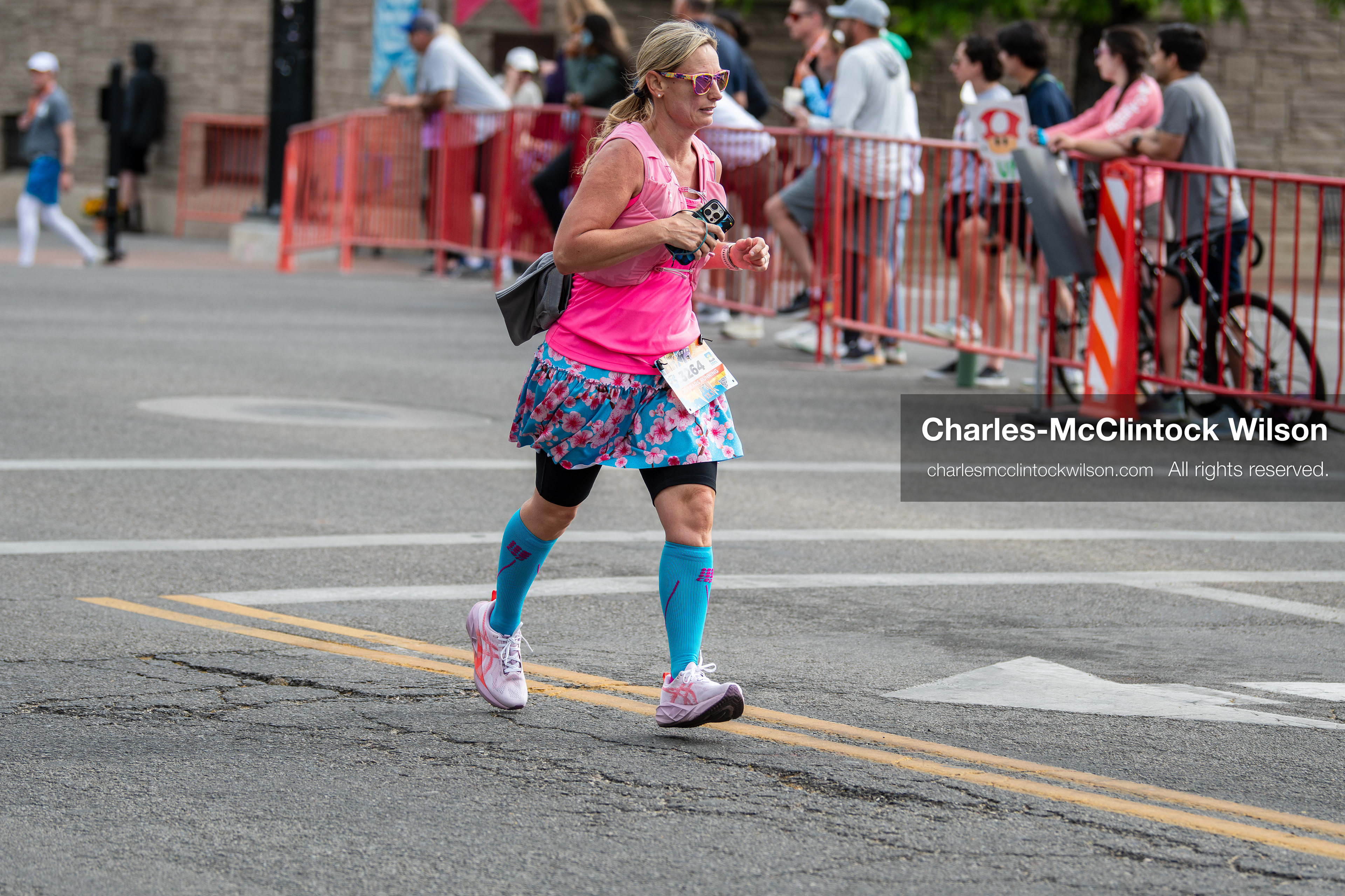 May 16, 2026, Ogden, Utah, USA: A runner wearing a bright pink top and patterned skirt competes in the 25th Annual America First Ogden Marathon in Ogden, Utah, on Saturday, May 16, 2026. Spectators line the course behind barricades as participants make their way through downtown streets during the milestone 25th running of the event. (Credit Image: © Charles-McClintock Wilson/ZUMA Press Wire)