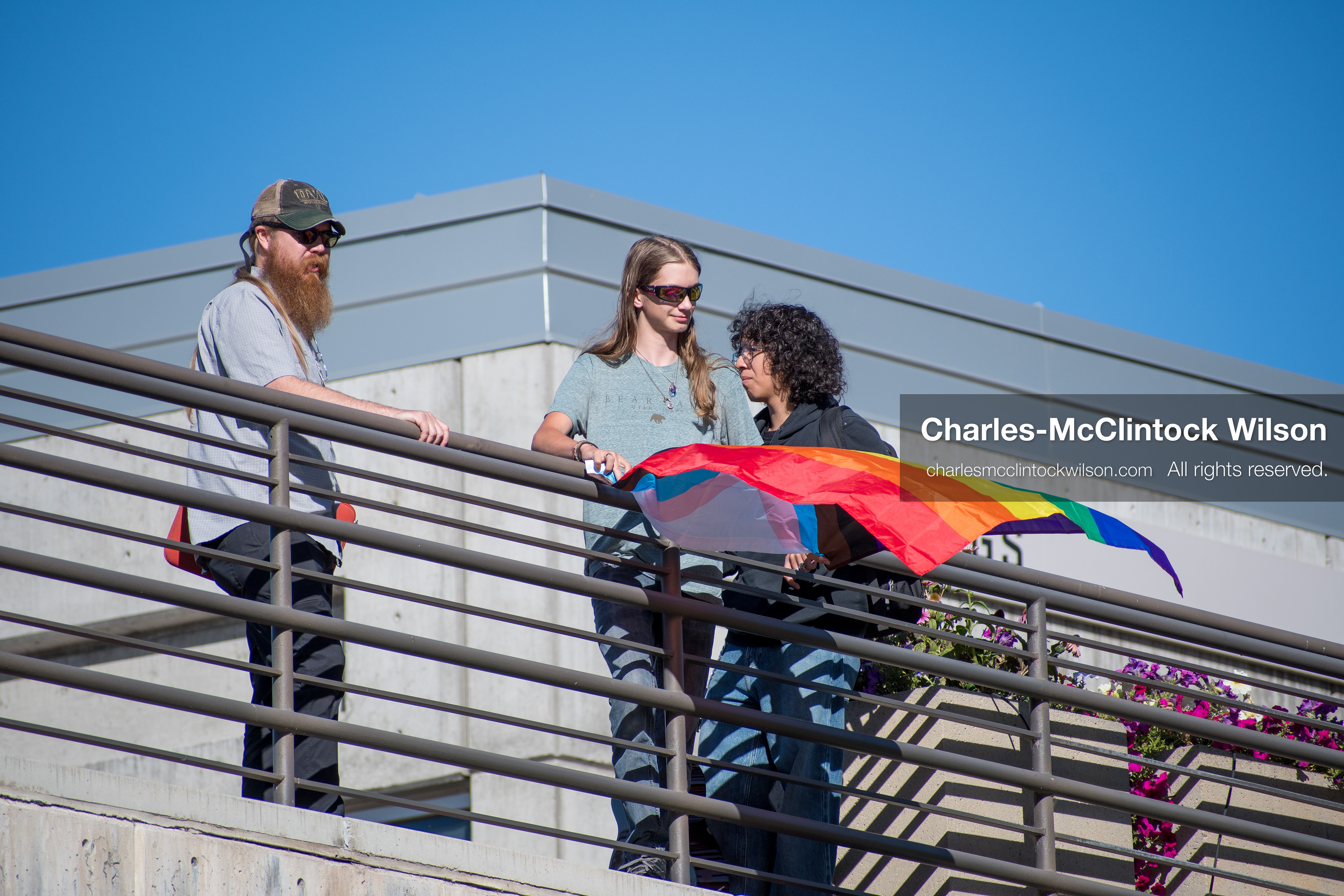 September 10, 2025, Orem, Utah, USA: A group of individuals stand atop the Fountain Courtyard at Utah Valley University, holding a Progress Pride flag during conservative activist Charlie Kirk’s American Comeback Tour appearance. The event drew over 3,000 attendees and was marked by heightened civic tension and symbolic gestures from both supporters and critics. Kirk was fatally shot moments later during the public Q&A session, prompting national scrutiny of campus security protocols and institutional response. (Credit Image: © Charles‑McClintock Wilson/ZUMA Press Wire)