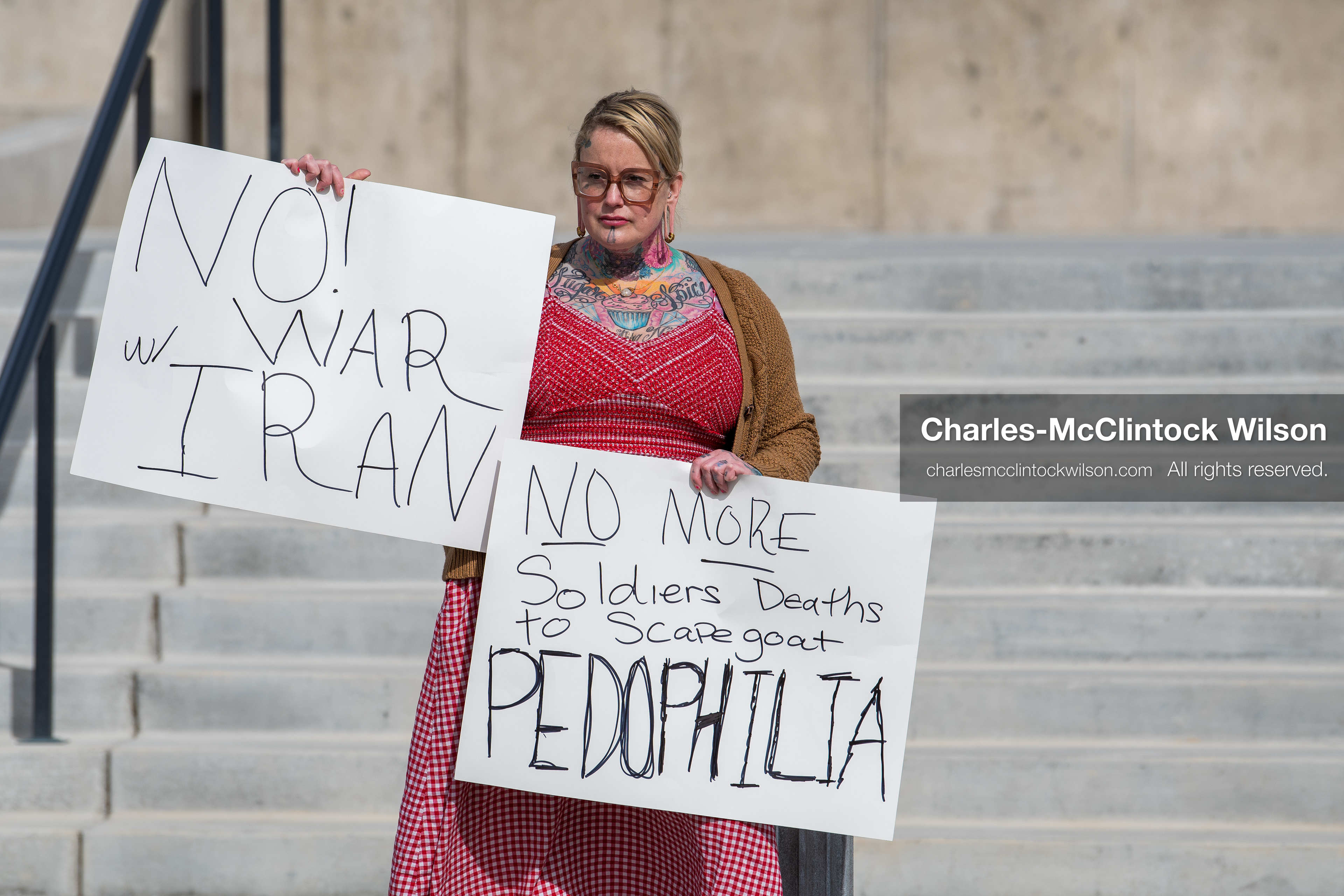 February 28, 2026, Salt Lake City, Utah, USA: A demonstrator stands on the steps of the Utah State Capitol holding two handwritten protest signs during the Stand With Ukraine rally. The gathering marked the four year anniversary of the full scale Russian invasion of Ukraine and brought community members together in support of Ukrainians and local humanitarian efforts. (Credit Image: © Charles McClintock Wilson/ZUMA Press Wire)