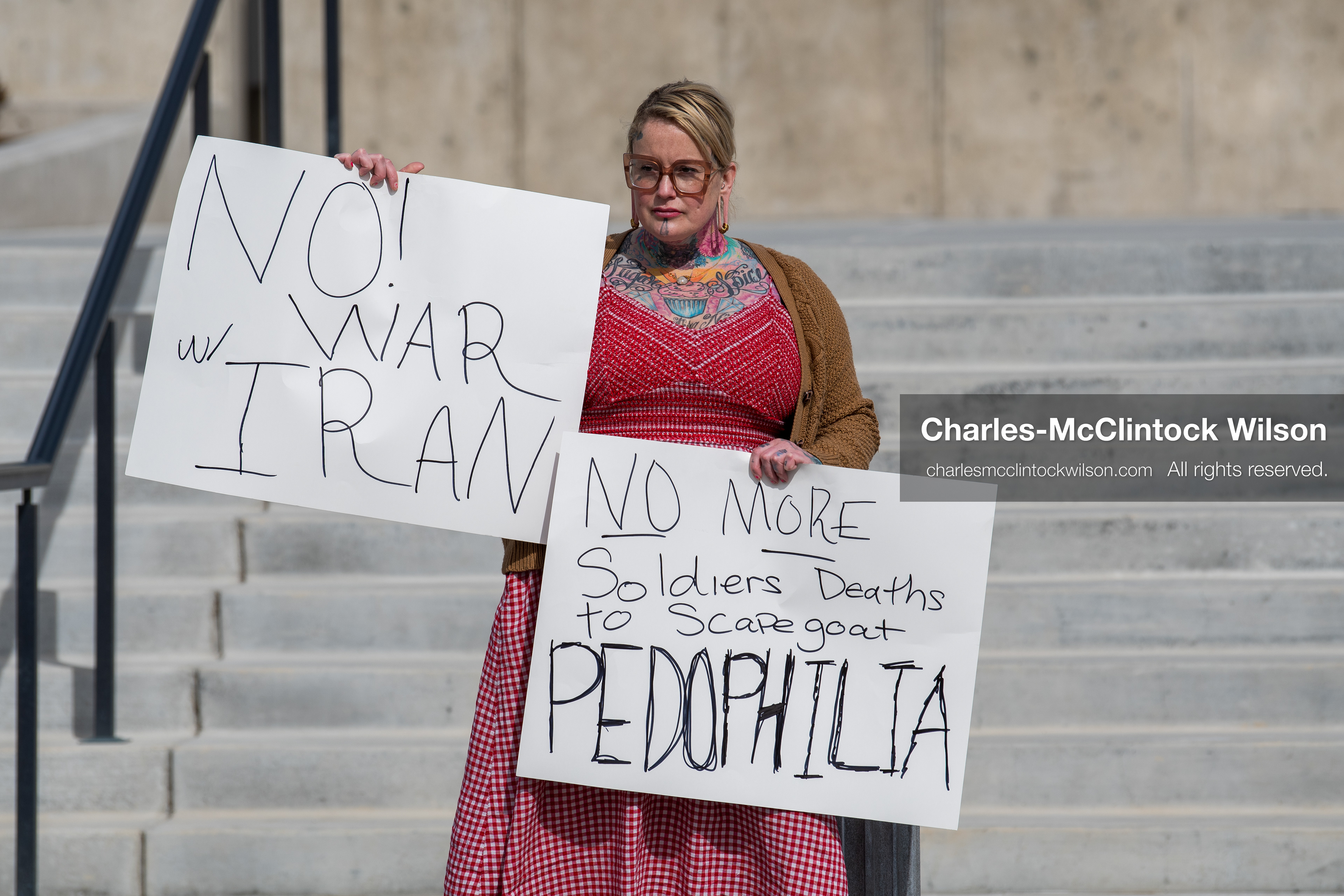 February 28, 2026, Salt Lake City, Utah, USA: A demonstrator stands on the steps of the Utah State Capitol holding two handwritten protest signs during the Stand With Ukraine rally. The gathering marked the four year anniversary of the full scale Russian invasion of Ukraine and brought community members together in support of Ukrainians and local humanitarian efforts. (Credit Image: © Charles McClintock Wilson/ZUMA Press Wire)