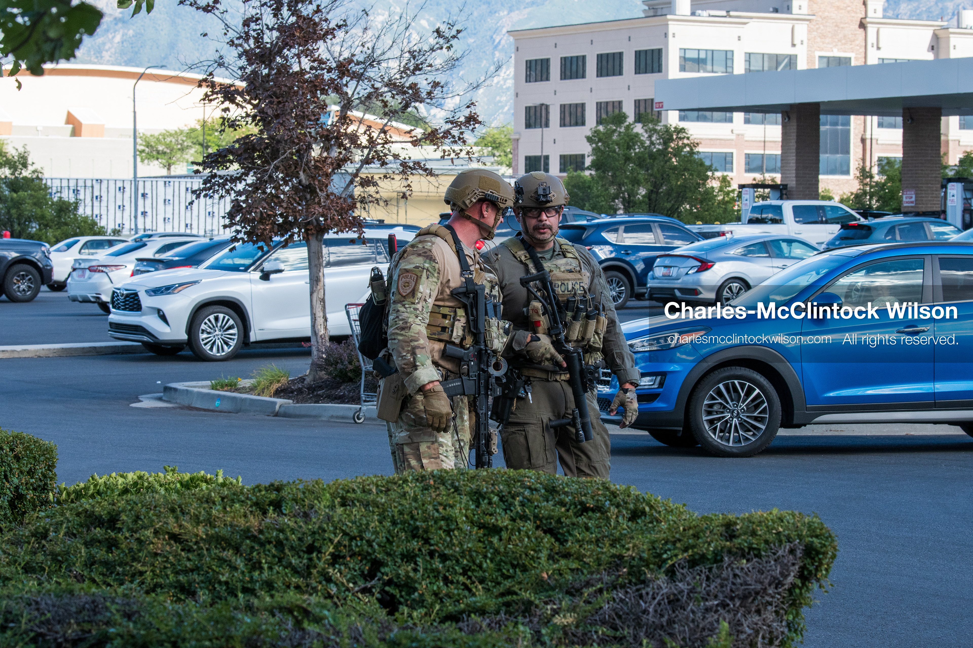 Two armed law enforcement officers in tactical gear and helmets patrol the parking area outside Intermountain Medical Center in Murray, Utah, on Monday, August 17, 2026. Multiple regional law enforcement agencies converged to heavily secure the hospital perimeter as a safety precaution after shooting victims arrived from a fatal shootout that erupted outside a funeral service in nearby Kearns earlier that day. (Photo by Charles-McClintock Wilson/Sipa USA)