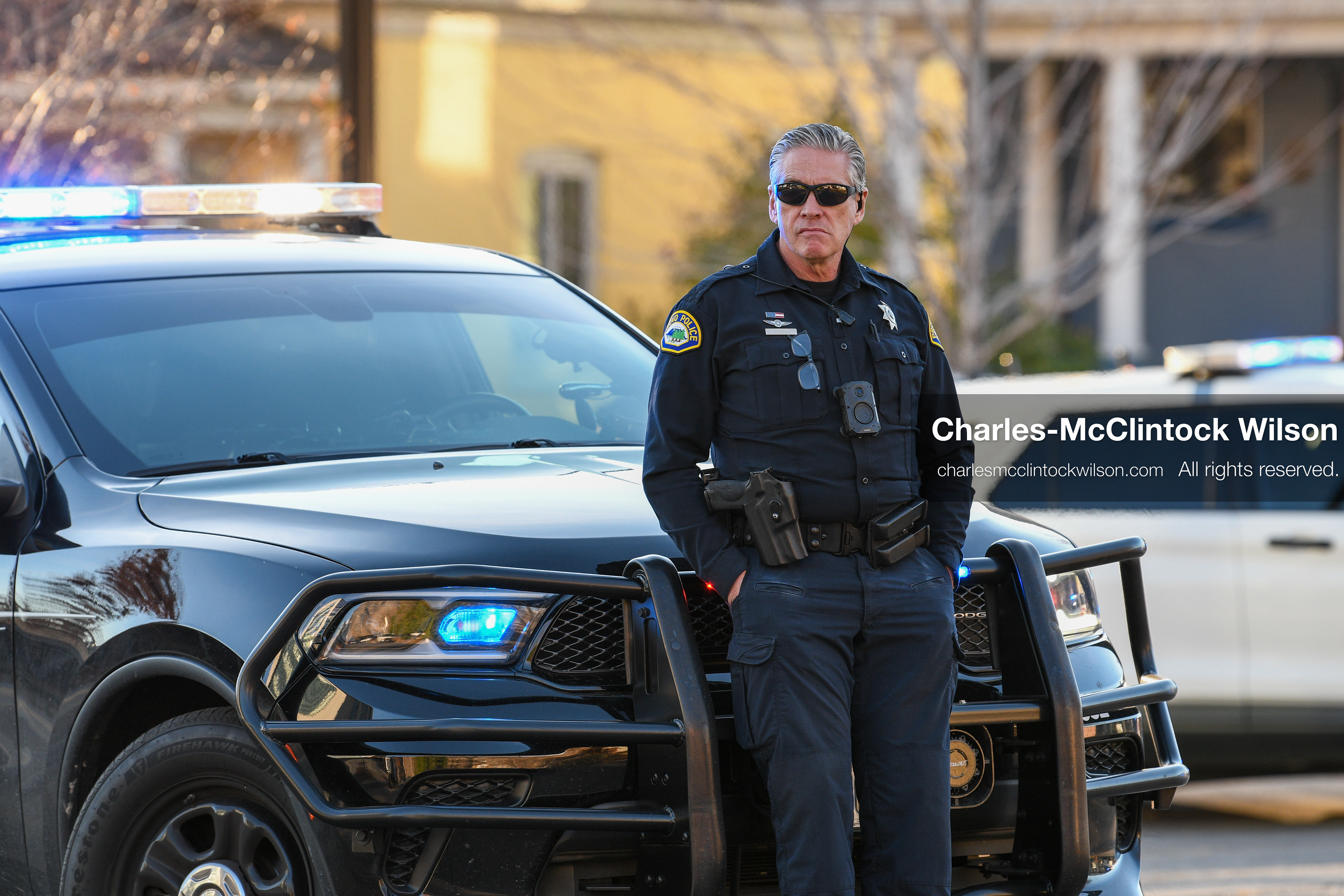 PROVO, UTAH, USA – DECEMBER 11, 2025: A Provo Police officer stands beside a patrol vehicle in a residential neighborhood near the Fourth District Court in Provo during the first in‑person court appearance of Tyler Robinson in the Charlie Kirk murder case. (Credit Image: © Charles‑McClintock Wilson/ZUMA Press Wire)