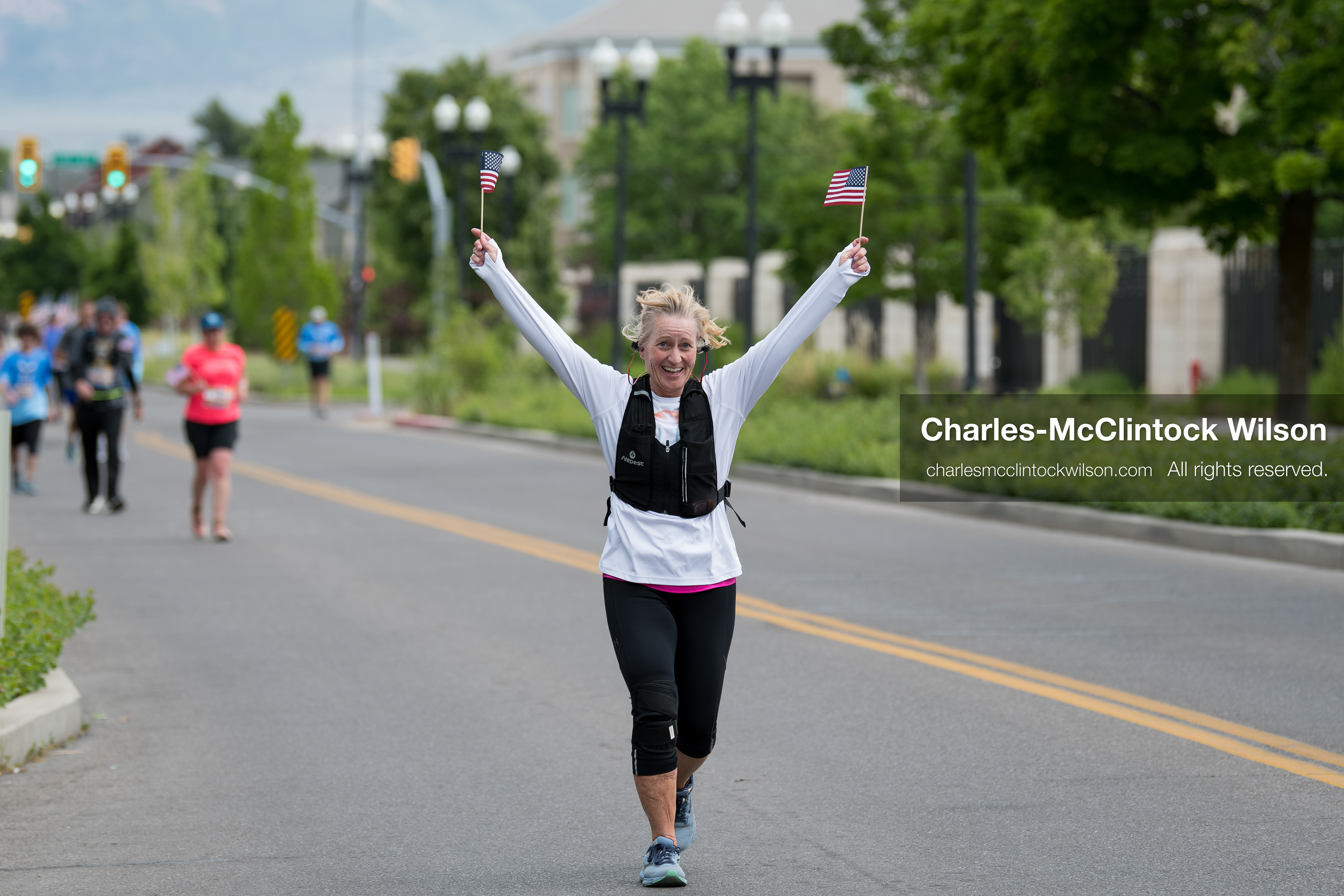 May 16, 2026, Ogden, Utah, USA: A runner waves two small American flags while participating in the 25th Annual America First Ogden Marathon in Ogden, Utah, on Saturday, May 16, 2026. The event marked the 25th running of the marathon, drawing thousands of participants and spectators. (Credit Image: © Charles-McClintock Wilson/ZUMA Press Wire)