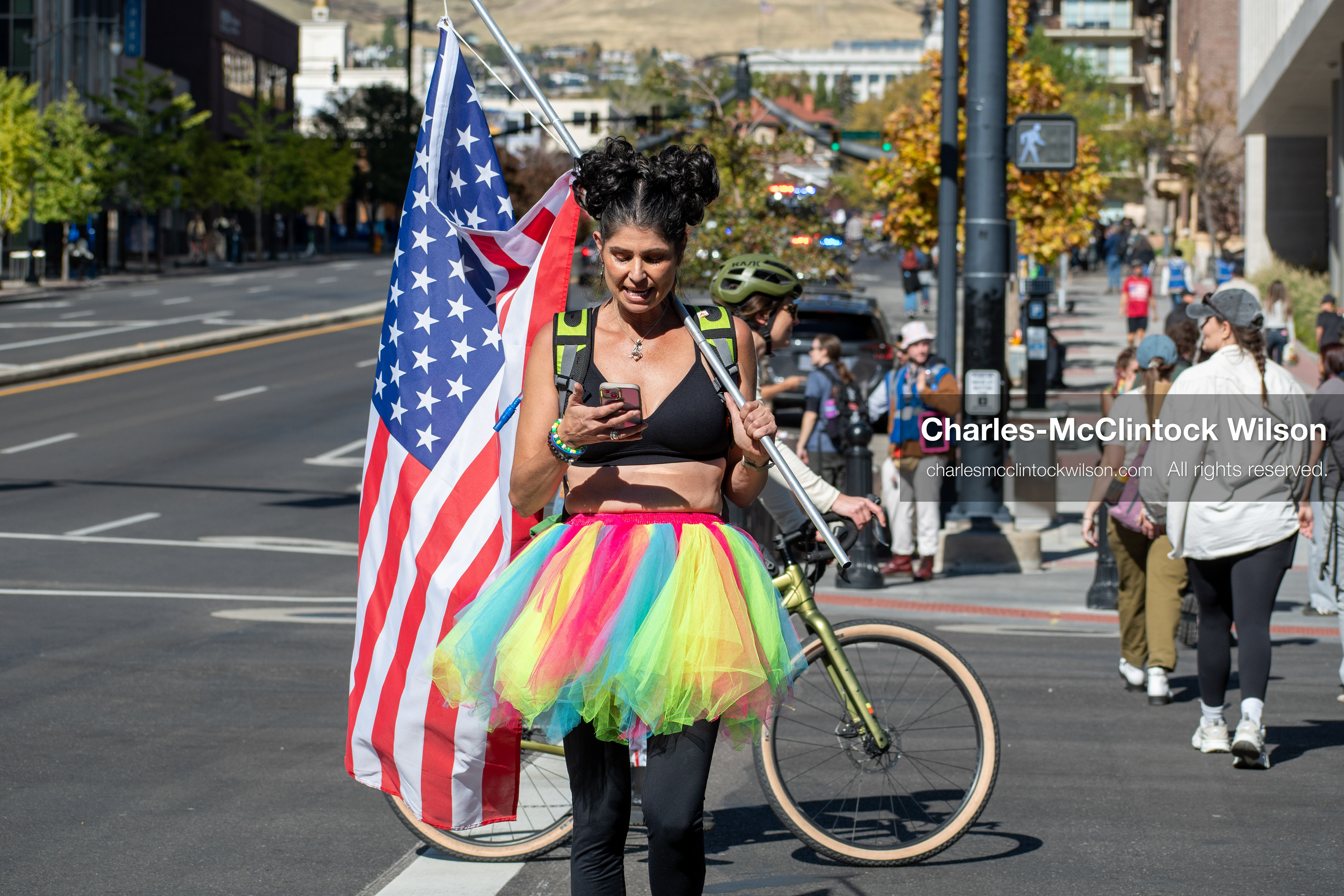 October 18, 2025, Salt Lake City, Utah, USA: A demonstrator wearing a rainbow tutu walks with an American flag during a "No Kings" protest in Salt Lake City, Utah. The protest was part of a nationwide mobilization.