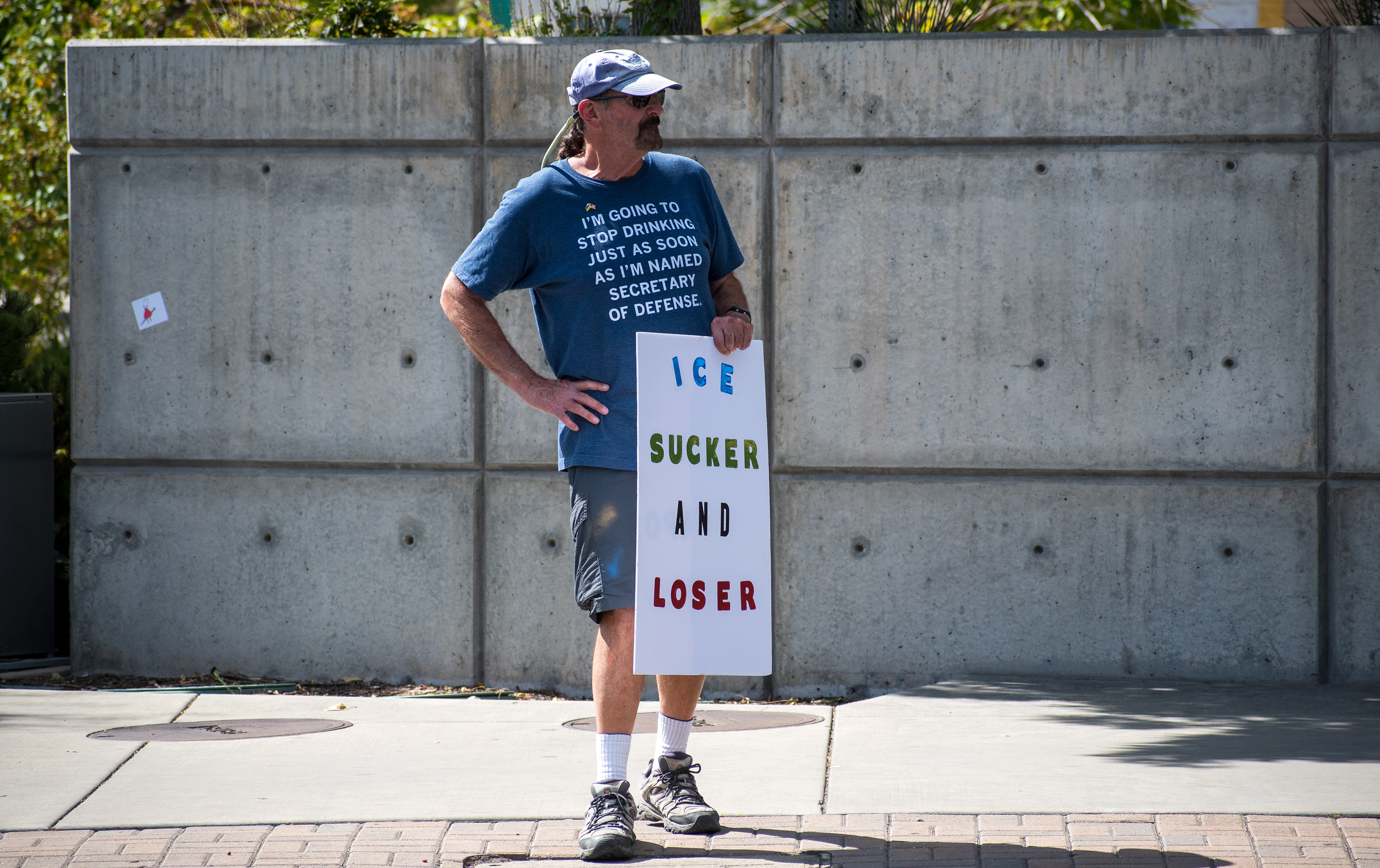 September 15, 2025 – Provo, Utah, United States: A demonstrator stands outside the Utah Valley Convention Center holding a protest sign reading “ICE SUCKER AND LOSER” during the Department of Homeland Security career expo. The individual’s shirt adds satirical commentary on political division and federal leadership. Photograph by Charles‑McClintock Wilson / ZUMA Press Wire