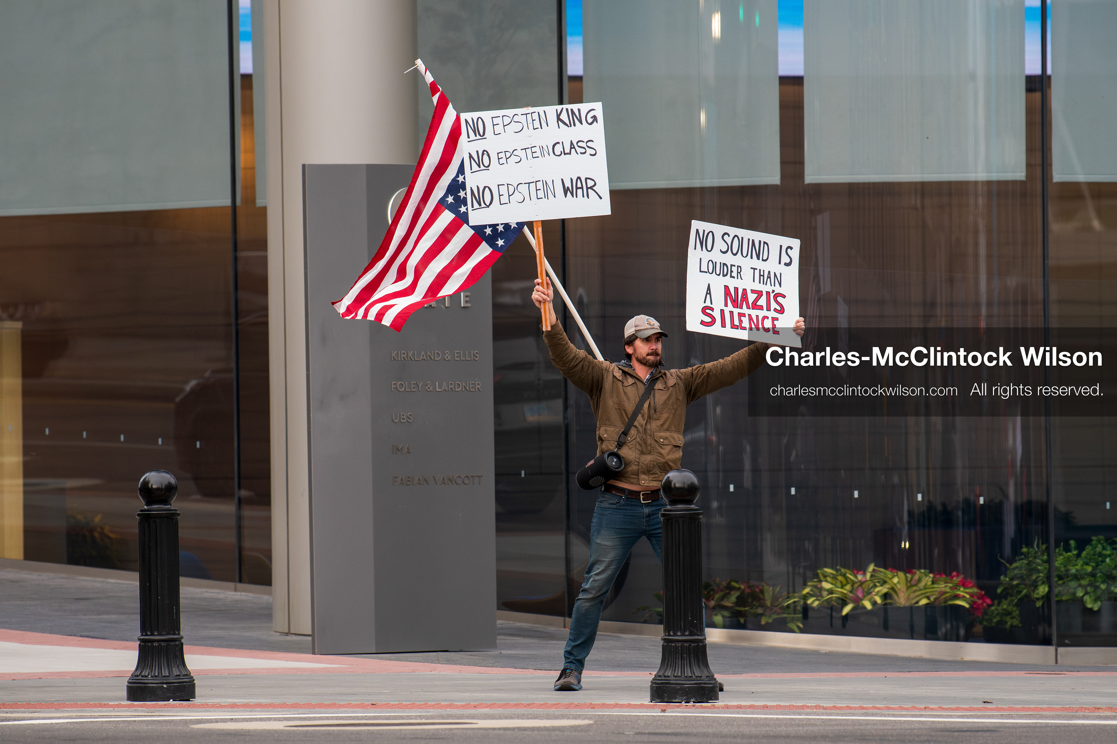 January 3, 2026, Salt Lake City, Utah, USA: A protester holds signs and an American flag during a demonstration against US action in Venezuela outside the Wallace Federal Building in Salt Lake City, Utah. The protest was part of a nationwide mobilization responding to recent military developments. (Credit Image: (c) Charles‑McClintock Wilson/ZUMA Press Wire)
