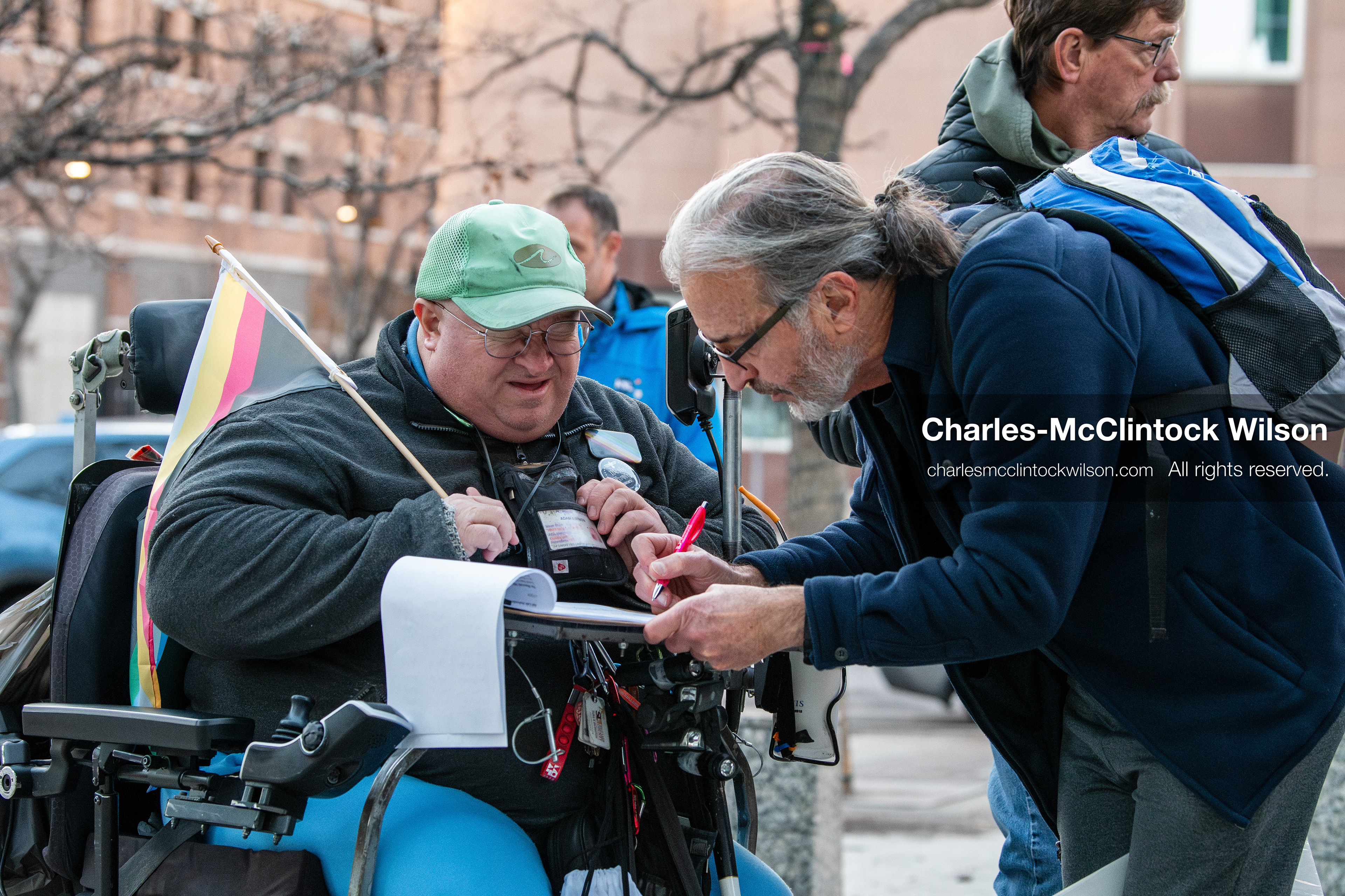 January 5, 2026, Salt Lake City, Utah, USA: A demonstrator signs a petition addressed to the US senators from Utah, Mike Lee and John Curtis, during a protest outside the Wallace Federal Building in Salt Lake City, Utah. The rally, organized by Salt Lake Indivisible, called for congressional limits on presidential war powers following recent US military actions in Venezuela involving the government of Nicolas Maduro. Another attendee assists with the signature process. (Credit Image: (c) Charles‑McClintock Wilson/ZUMA Press Wire)